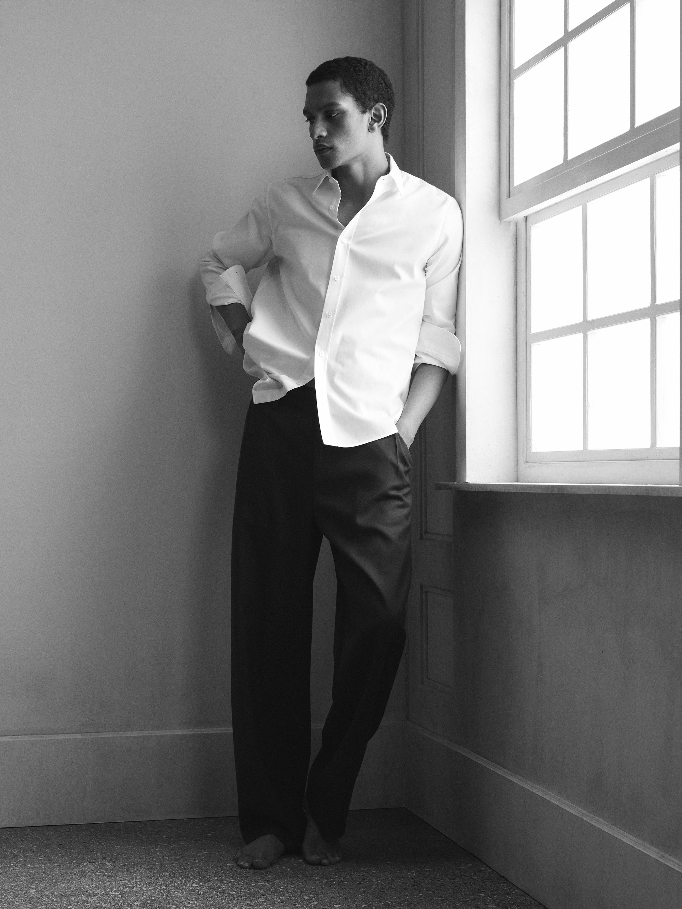 Uzun kollu beyaz gömlek ve düz kesim siyah pantolon takımı.