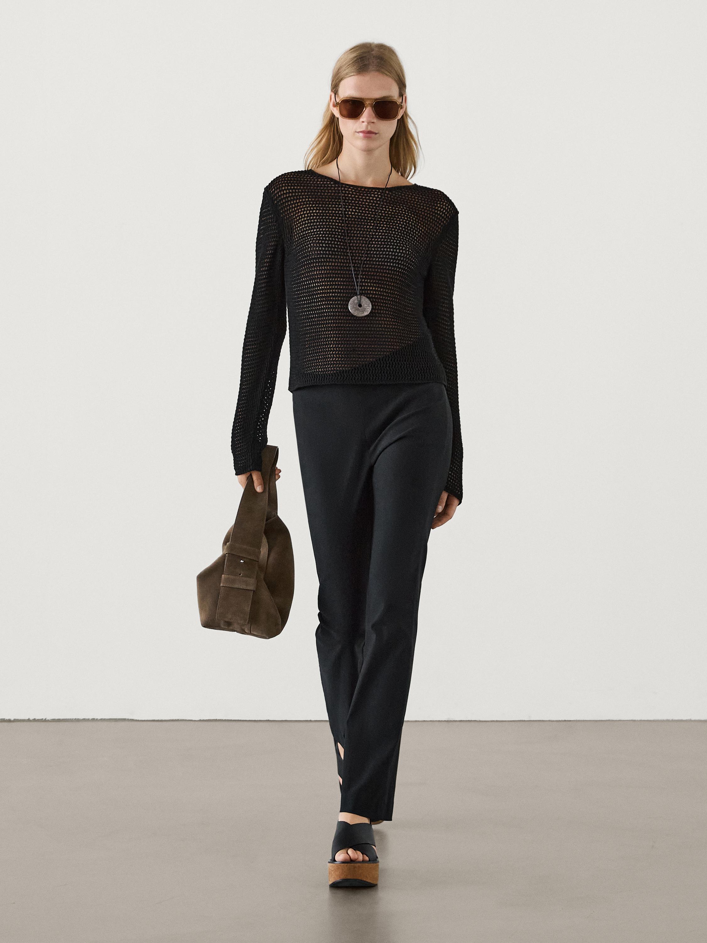 Ensemble pantalon noir et pull en maille noire avec lunettes de soleil et sac marron