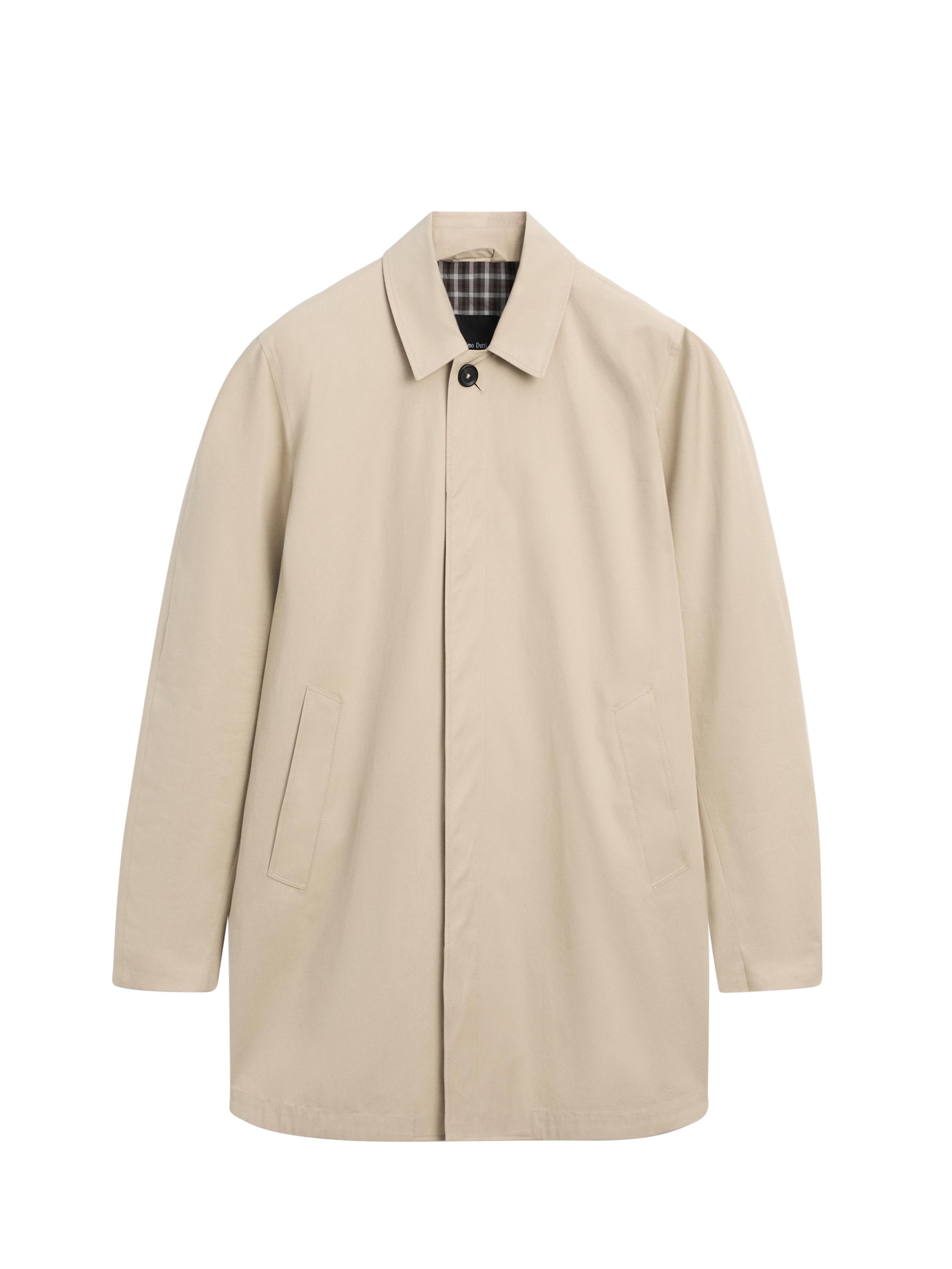 Vista frontal de gabardina bege com gola clássica, fecho de botão oculto e bolsos laterais. Interior com detalhe de xadrez.