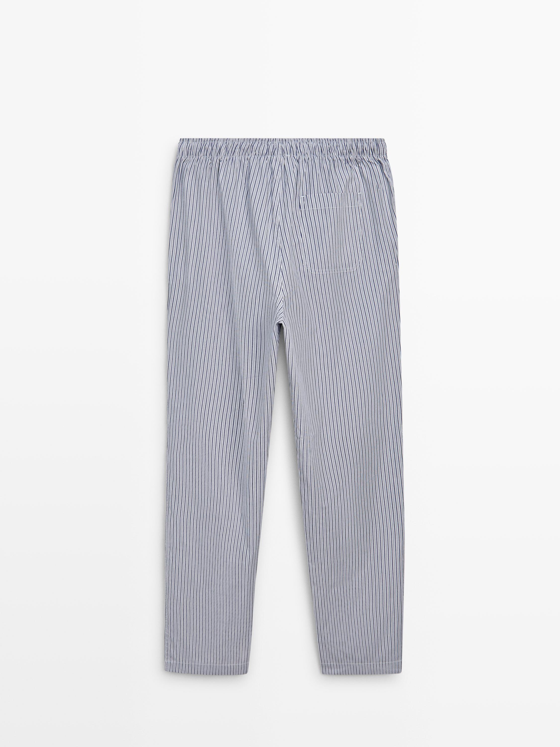 Vista frontal de pantalón de pixama azul con raias verticais e cintura elástica.