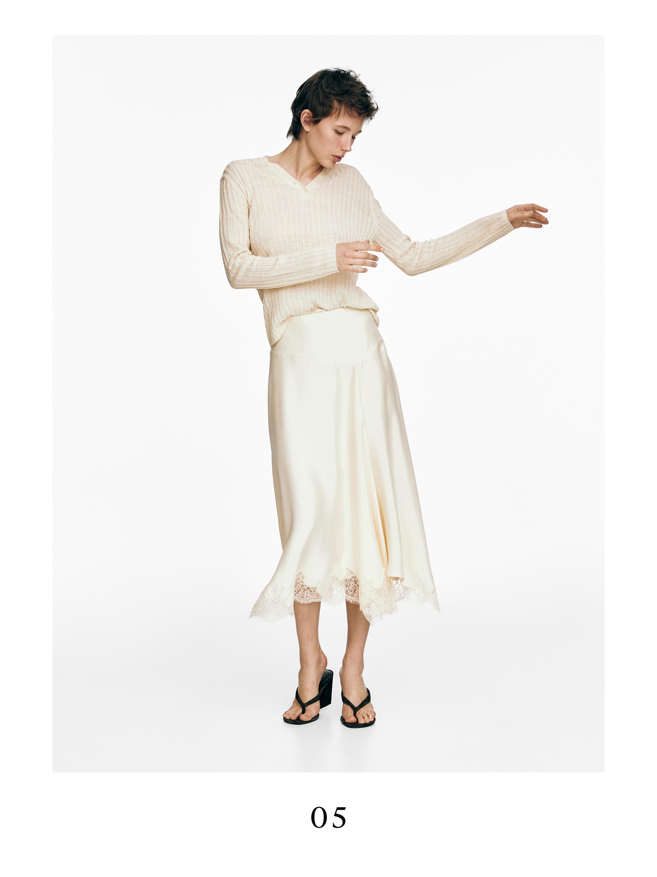 Σετ ασύμμετρης φούστας βανίλια με δαντελένια λεπτομέρεια και μπεζ πουλόβερ μακρυμάνικο.