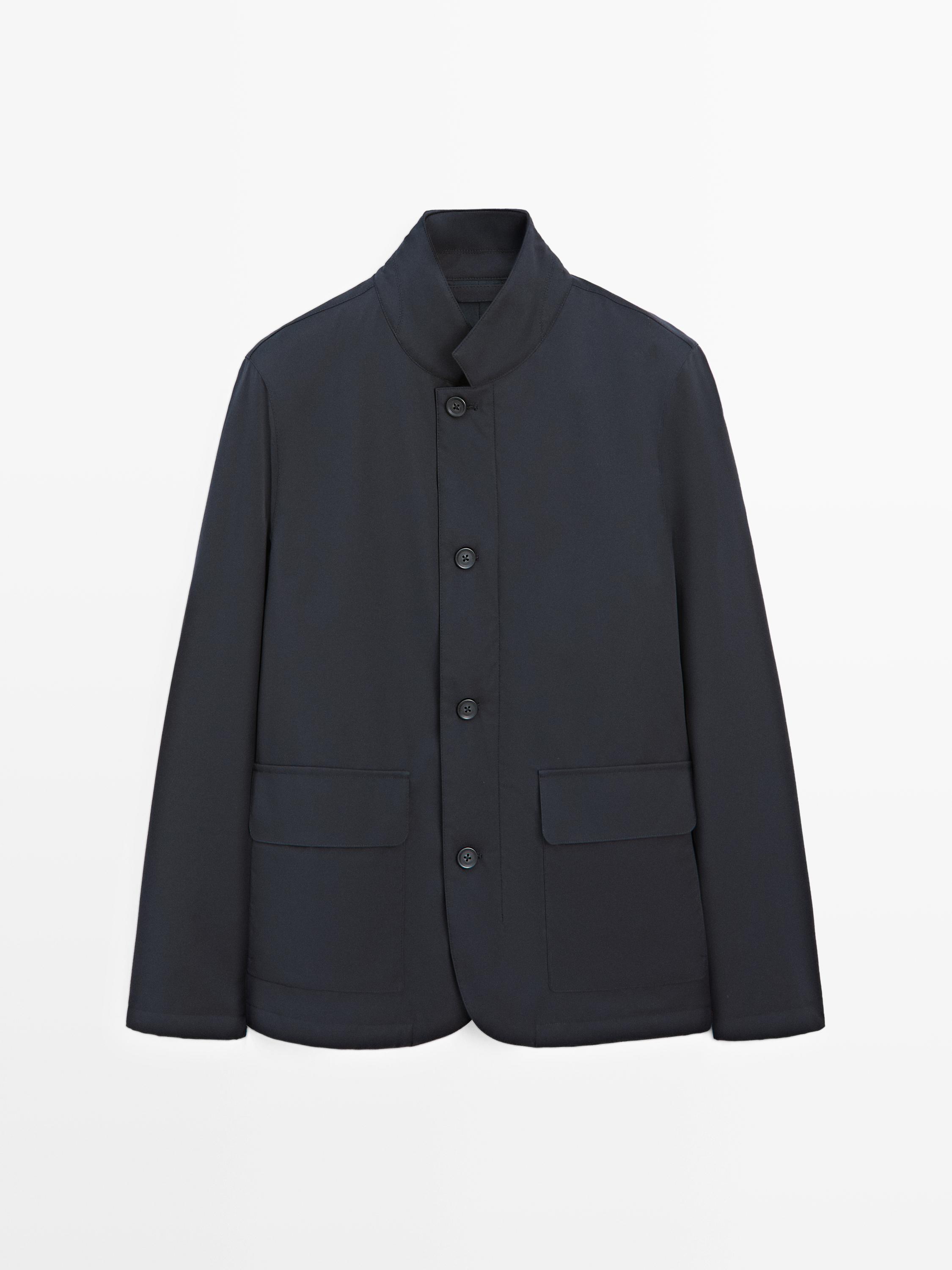 מבט מקדימה של ז'קט מרופד כחול כהה עם צווארון גבוה, סגירת כפתורים וכיסים קדמיים עם דש.