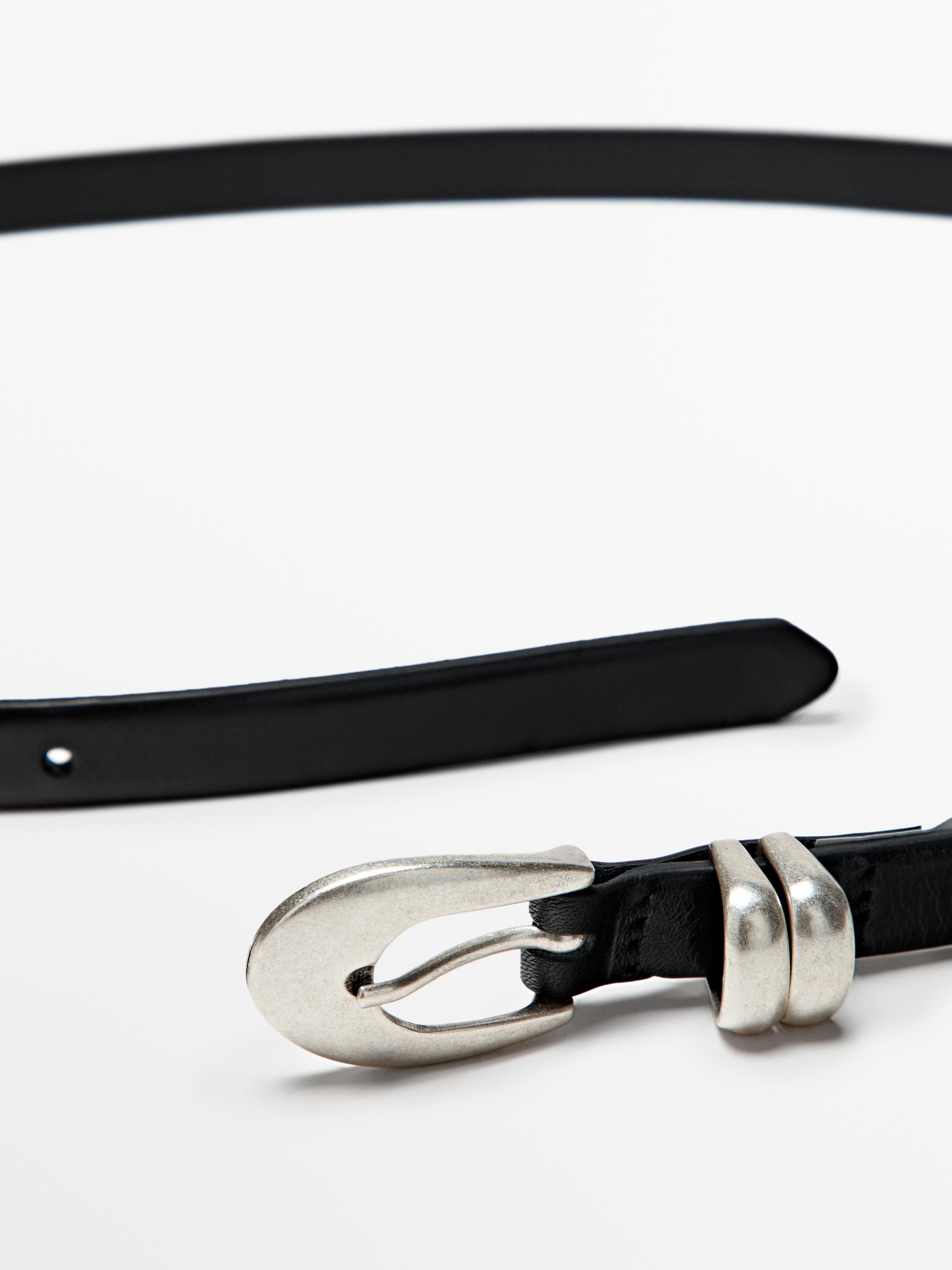 Detail of black belt with silver oval buckle and double loop.