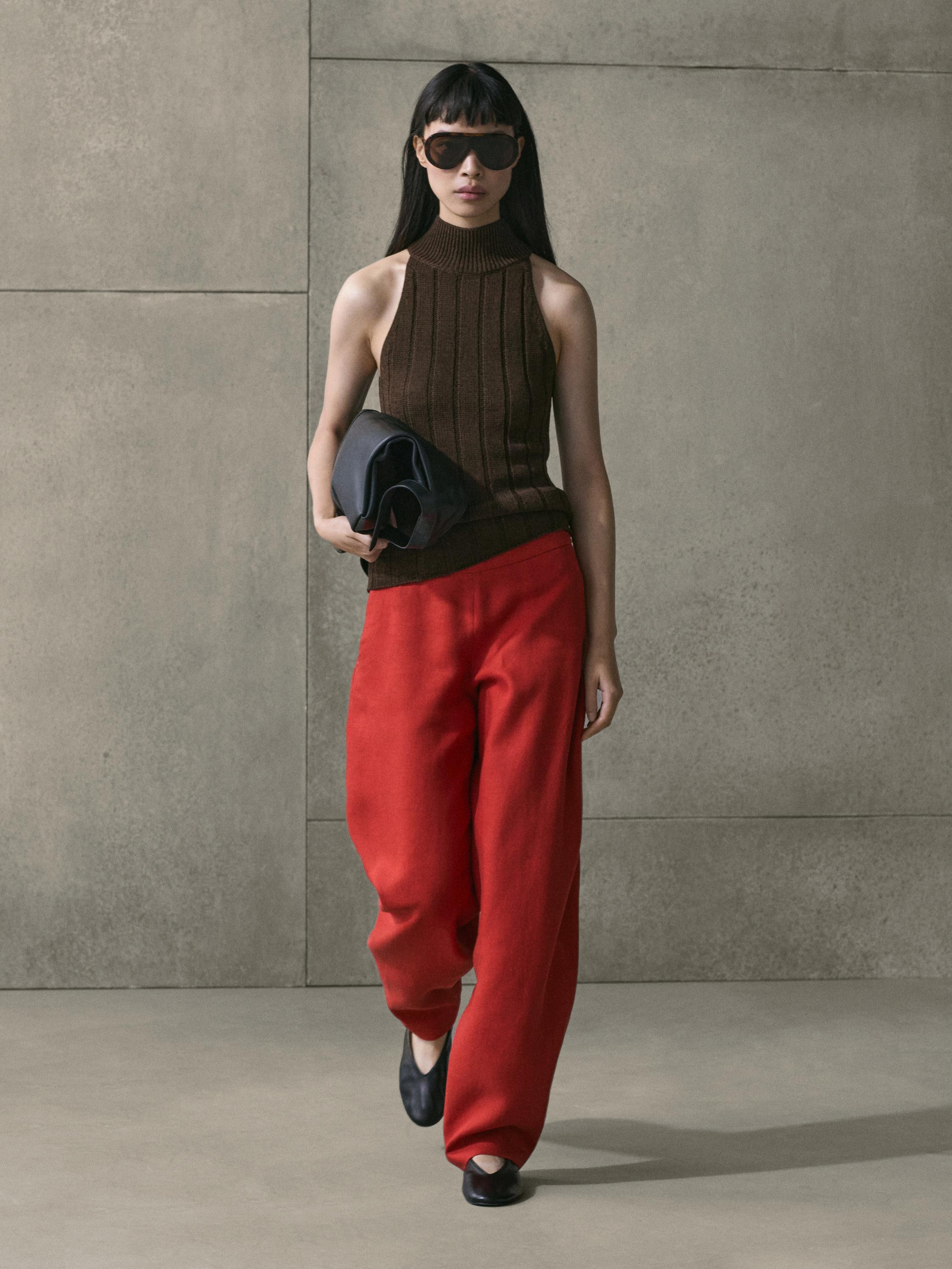 Ensemble pantalon rouge à volume et top marron sans manches à col roulé.
