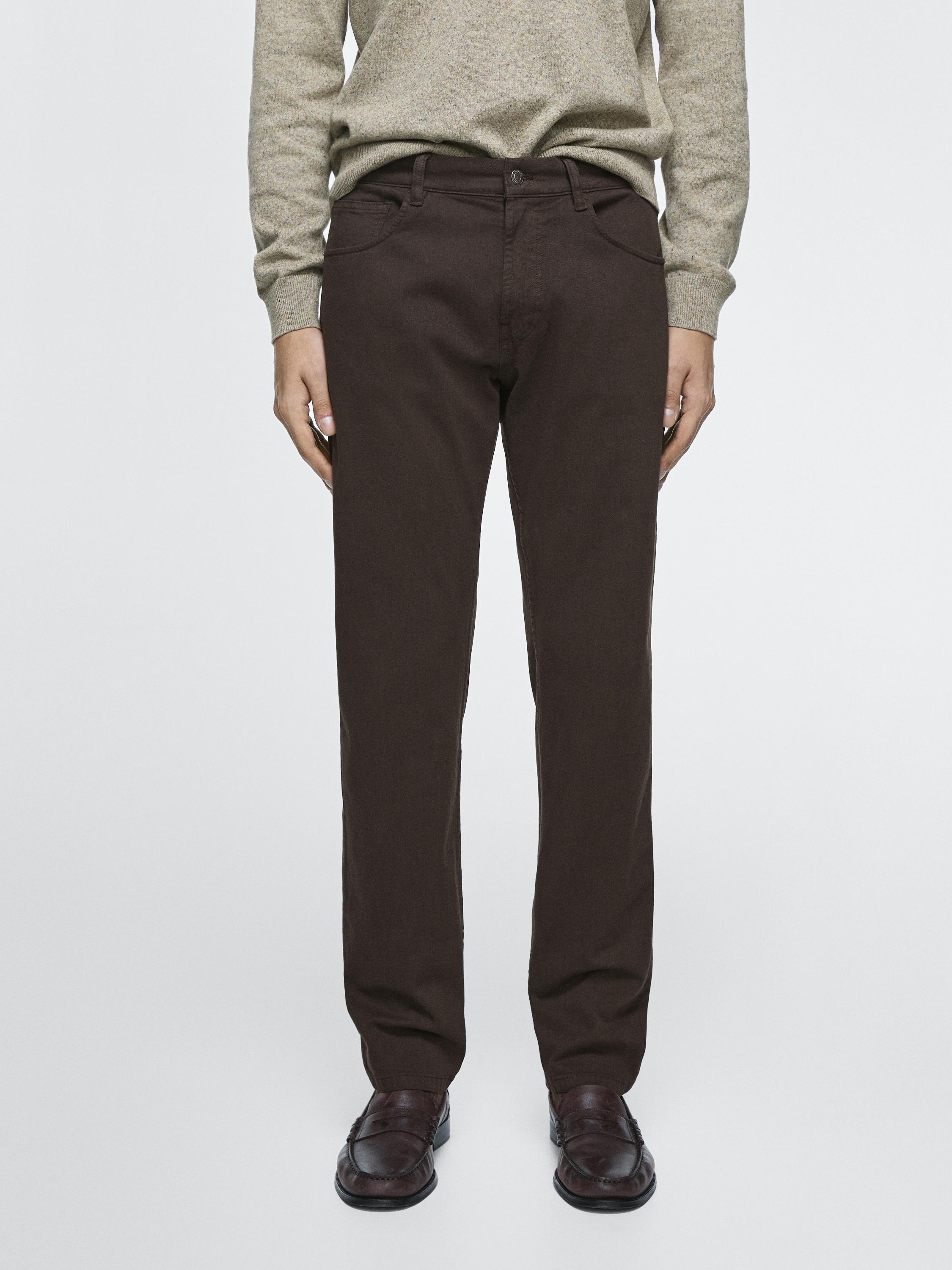 Ensemble de jeans marron coupe tapered avec poches avant et arrière, combinés à un pull beige.