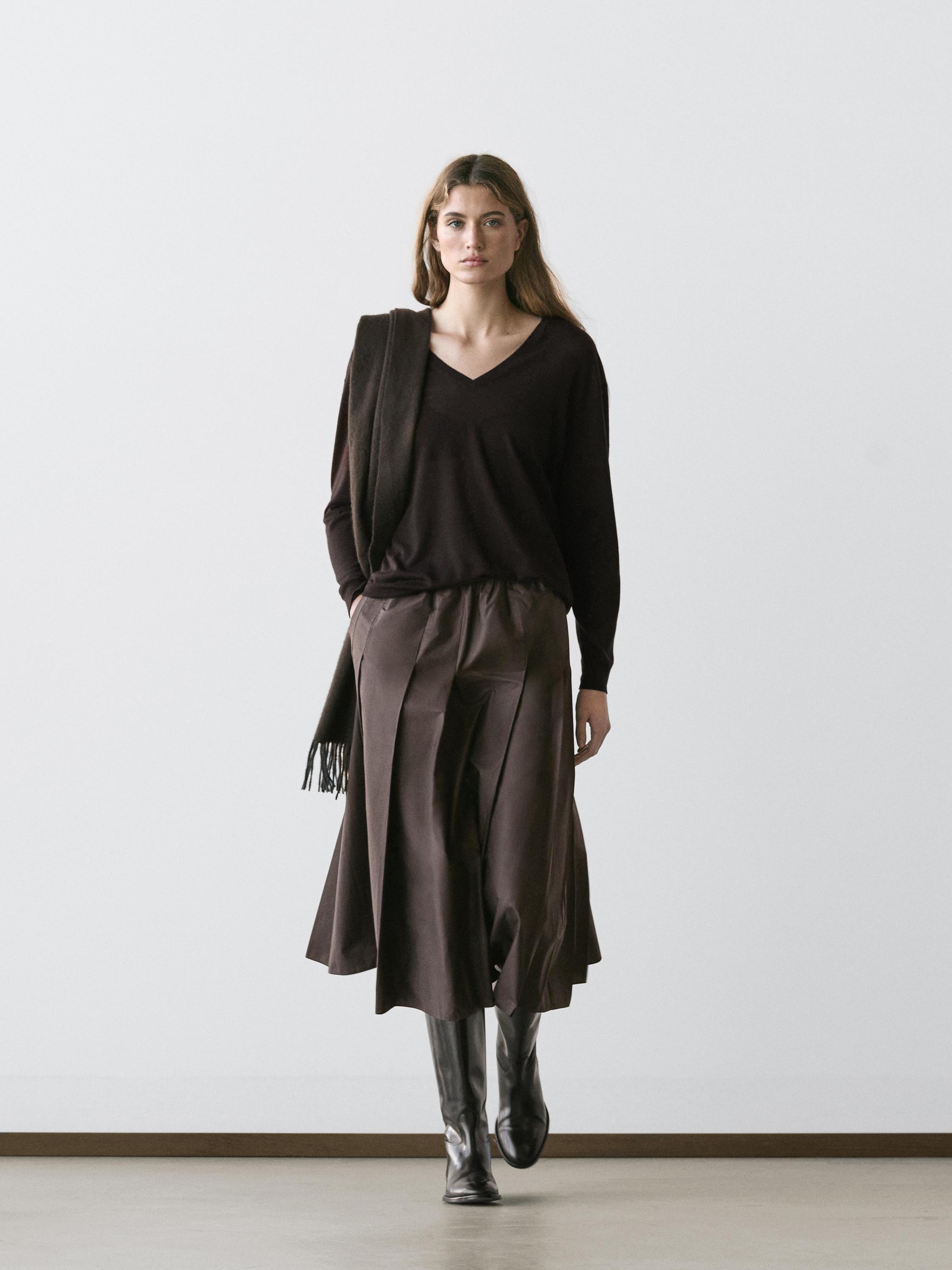 Brown sweater set, chocolate midi skirt with pleats, and black tall boots.