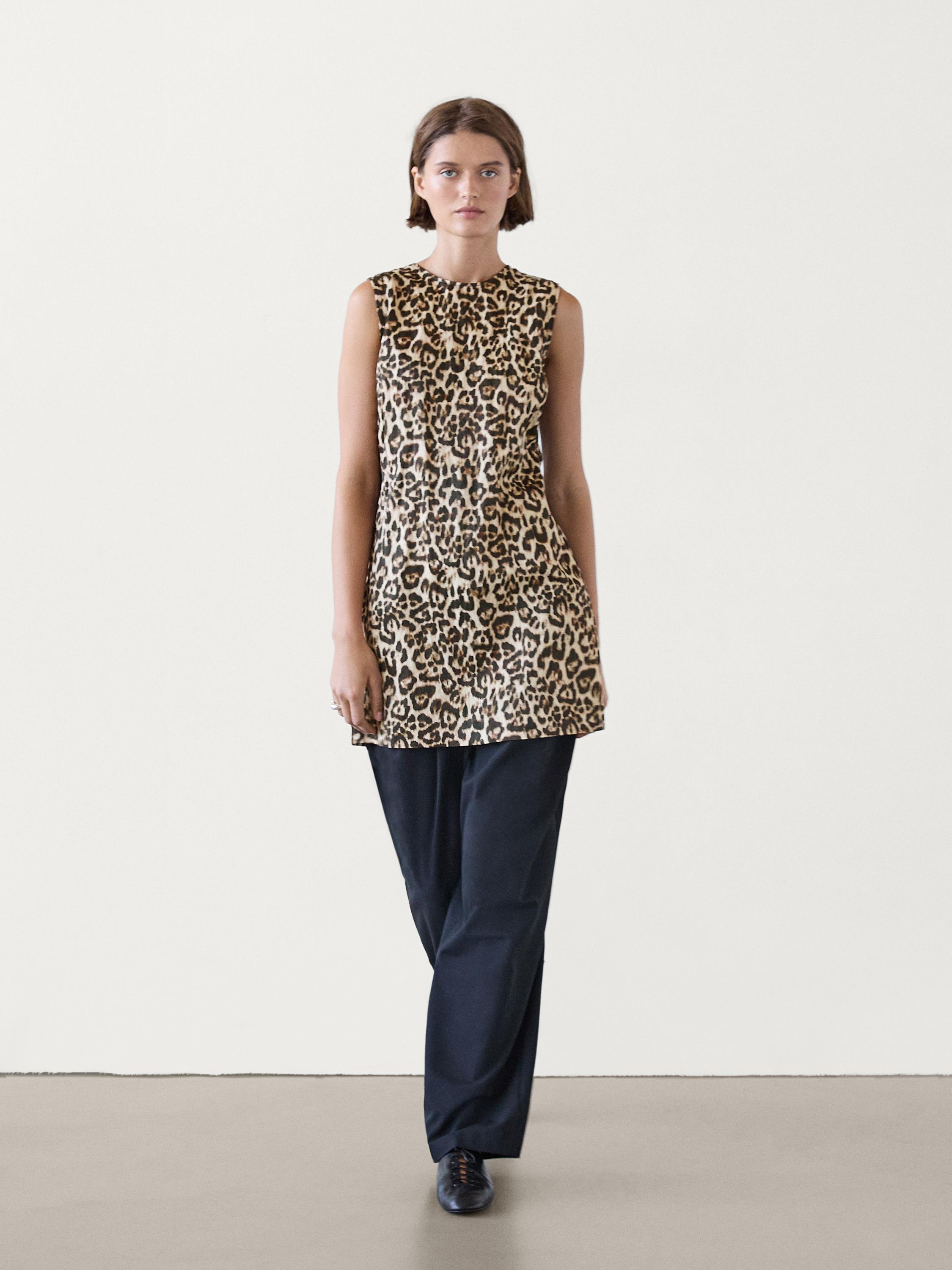 Ensemble comprenant une robe sans manches à imprimé léopard et un pantalon noir.