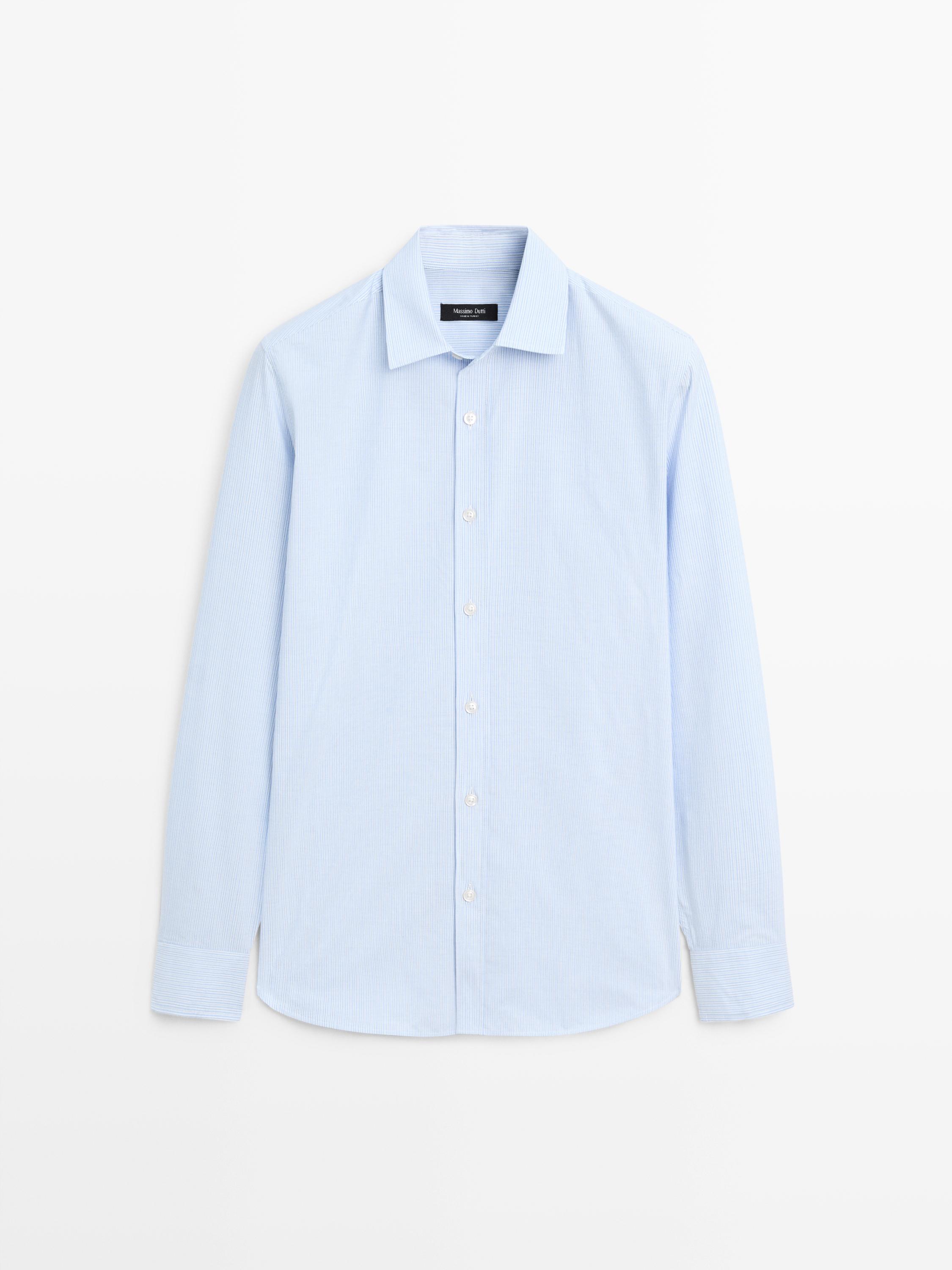 Vista frontale di camicia blu a righe con maniche lunghe e abbottonatura centrale.