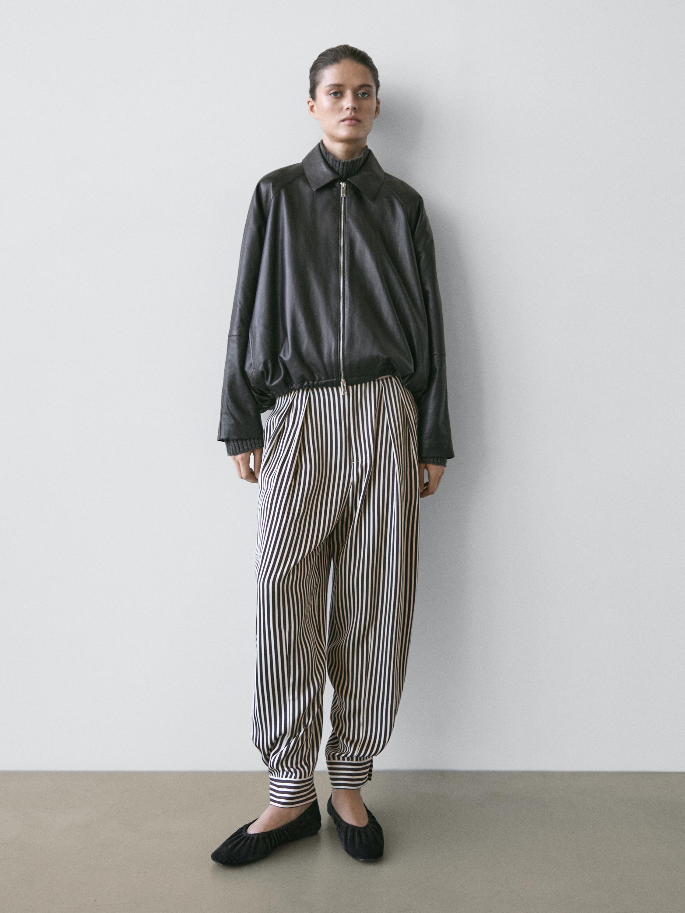 Black zippered jacket and black and white striped pants set.