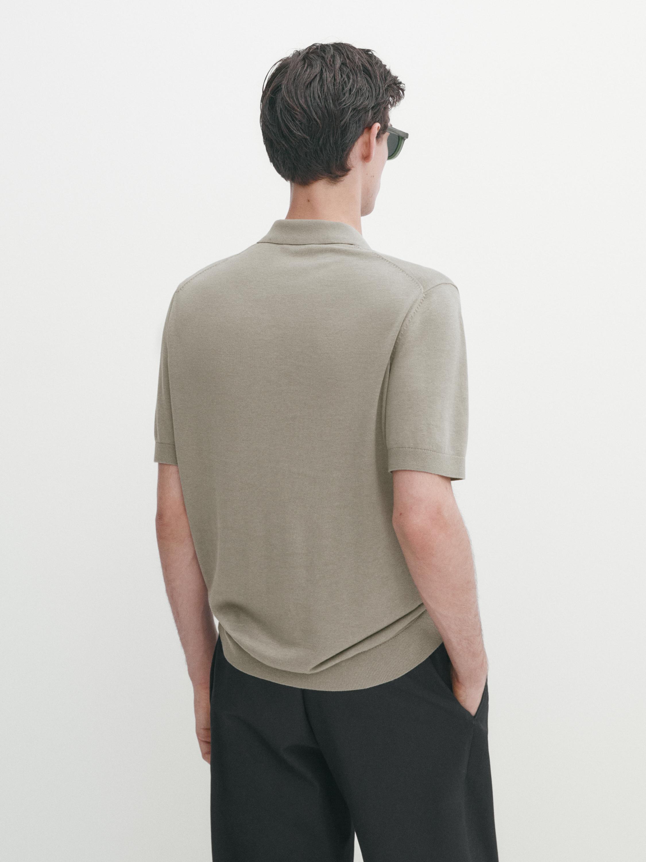 منظر خلفي لقميص بولو رمادي فاتح وبنطلون داكن