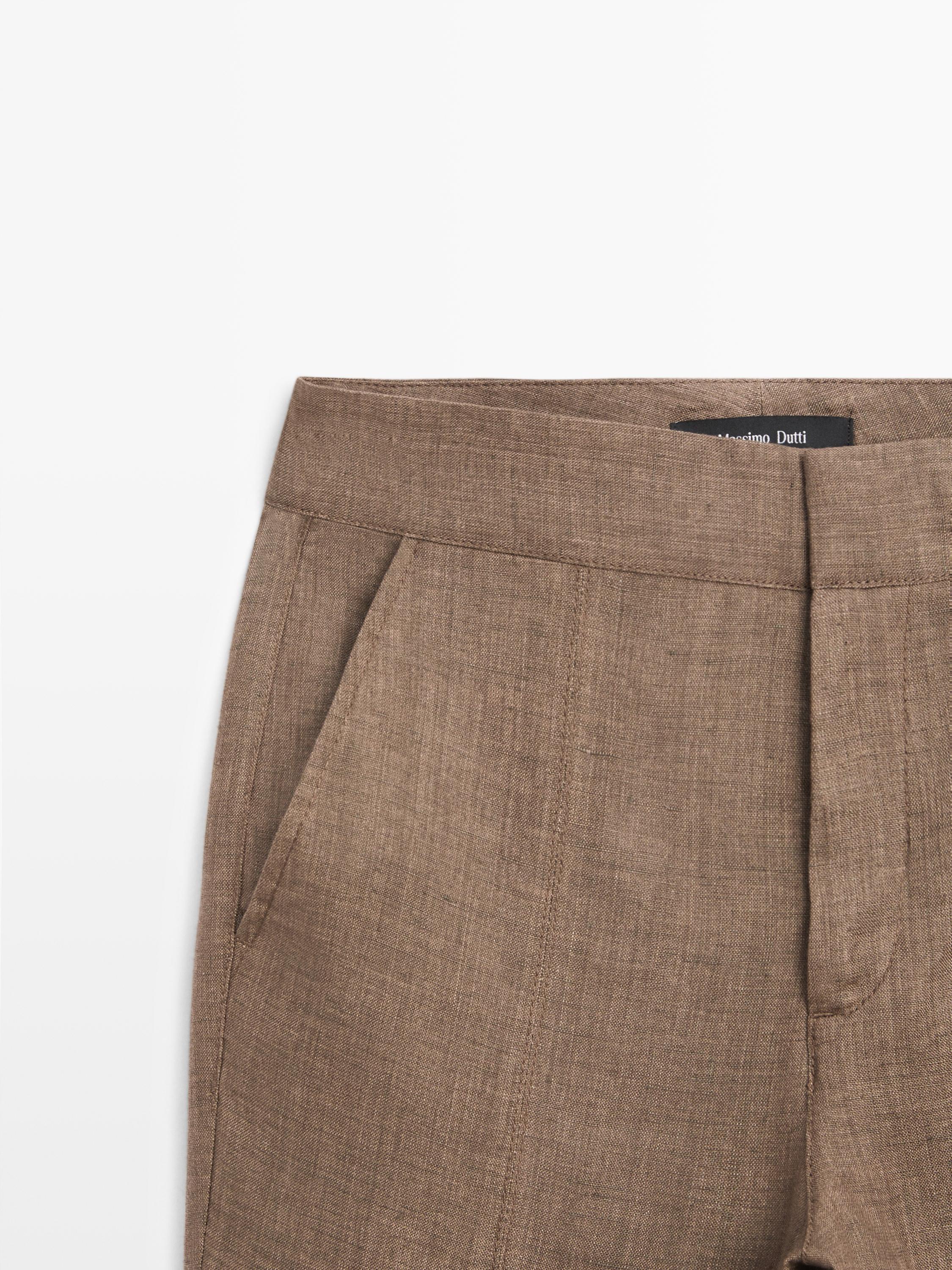 Plano medio de pantalón marrón con bolsillos laterales y cintura alta.