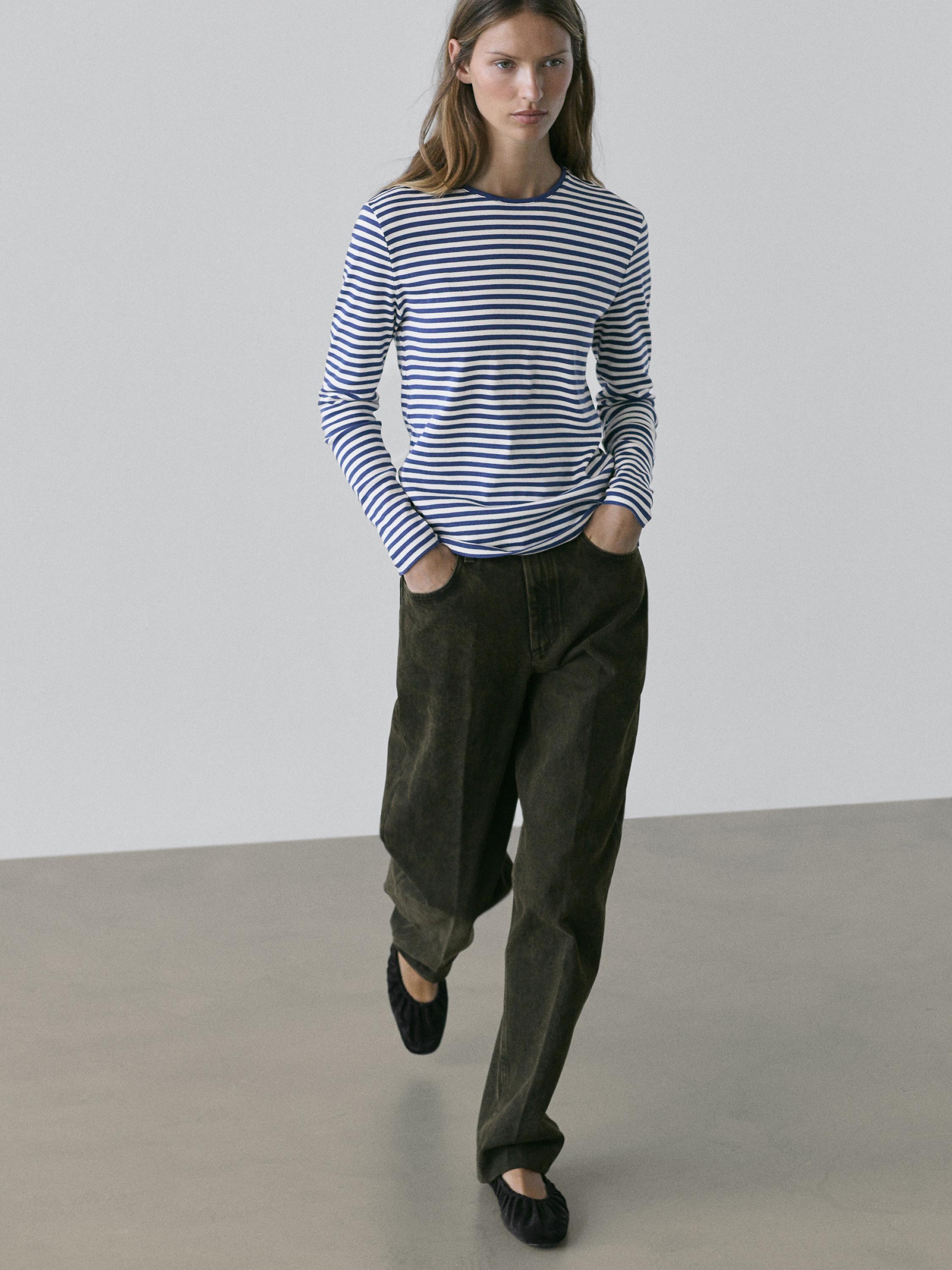 Ensemble t-shirt rayé bleu marine et blanc à manches longues et pantalon large vert foncé.