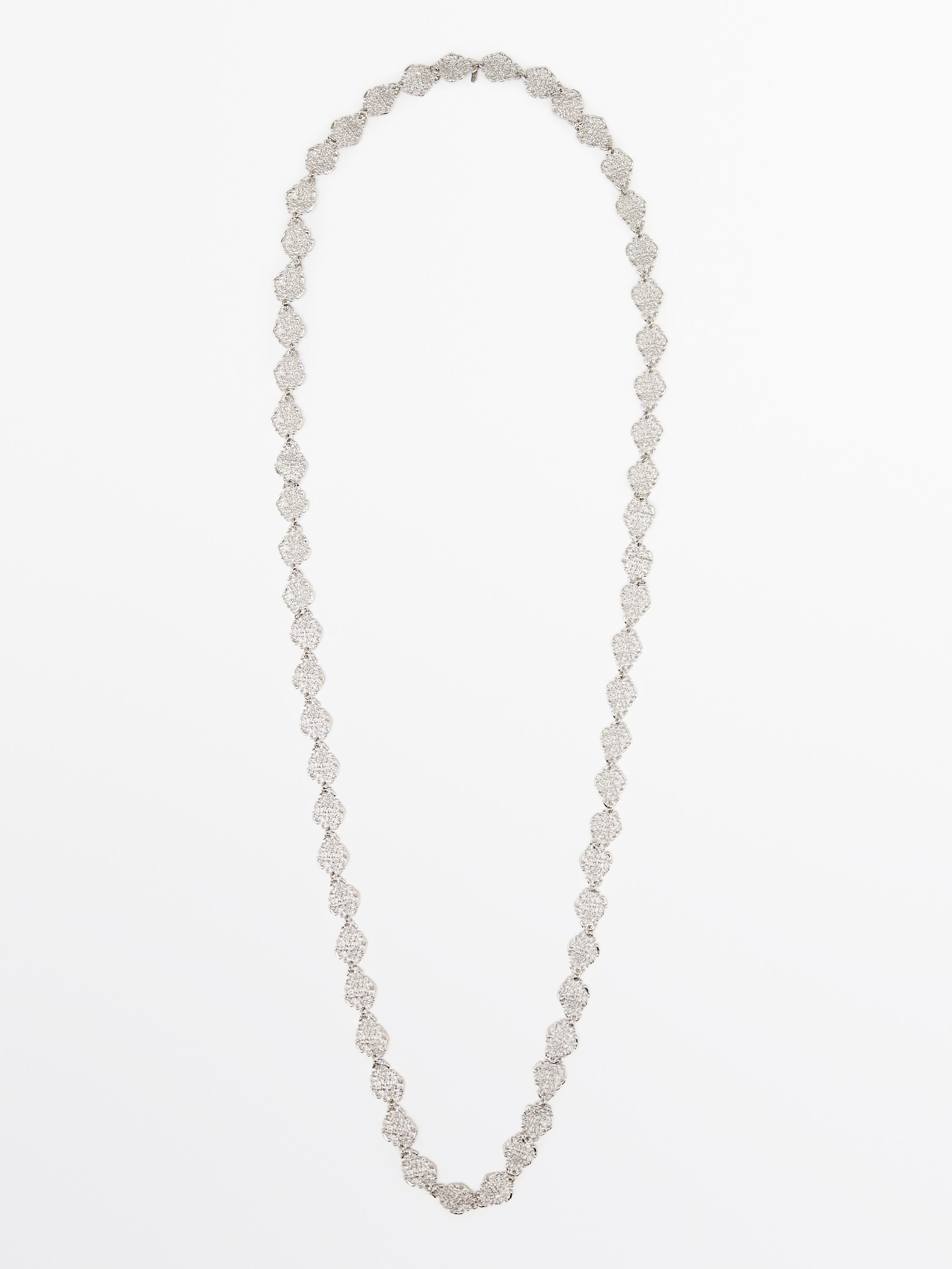 Вид спереду на довге біжутерне намисто срібного кольору з декоративними ланками у формі ромба.