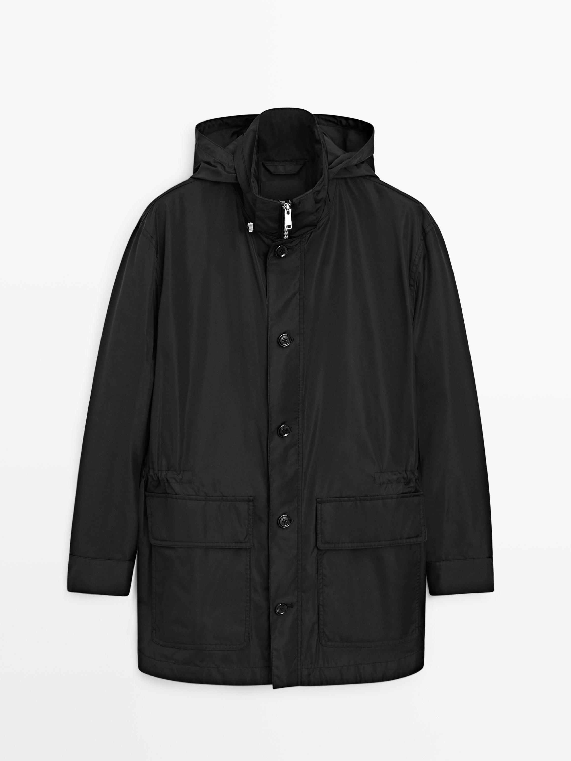 Mustast parakast eesvaade, kapuutsi, nööpide ja tõmblukuga kinnituse ning klapiga esitaskutega.