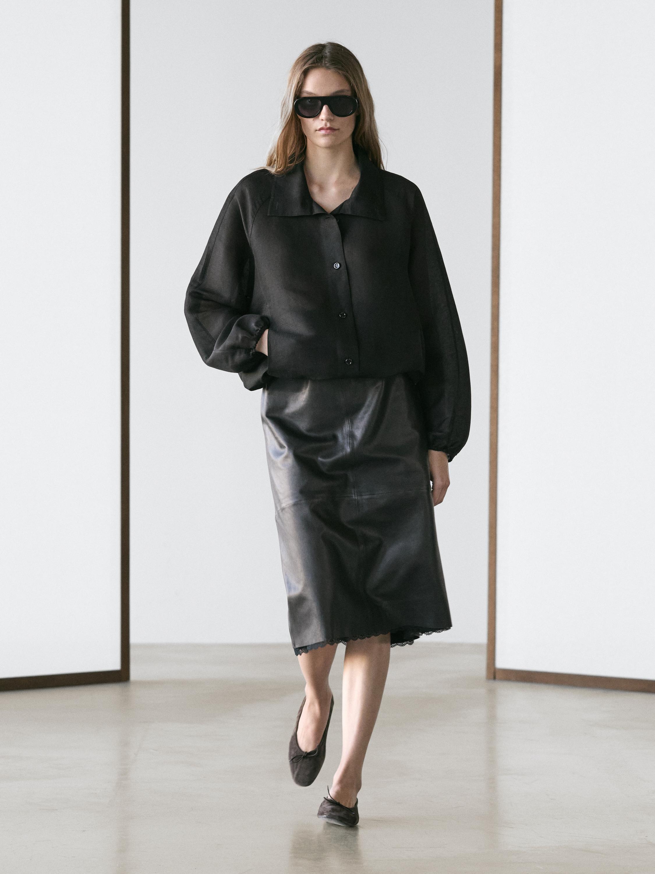 Set aus schwarzer Bomberjacke mit Knöpfen und schwarzem Midi-Rock.