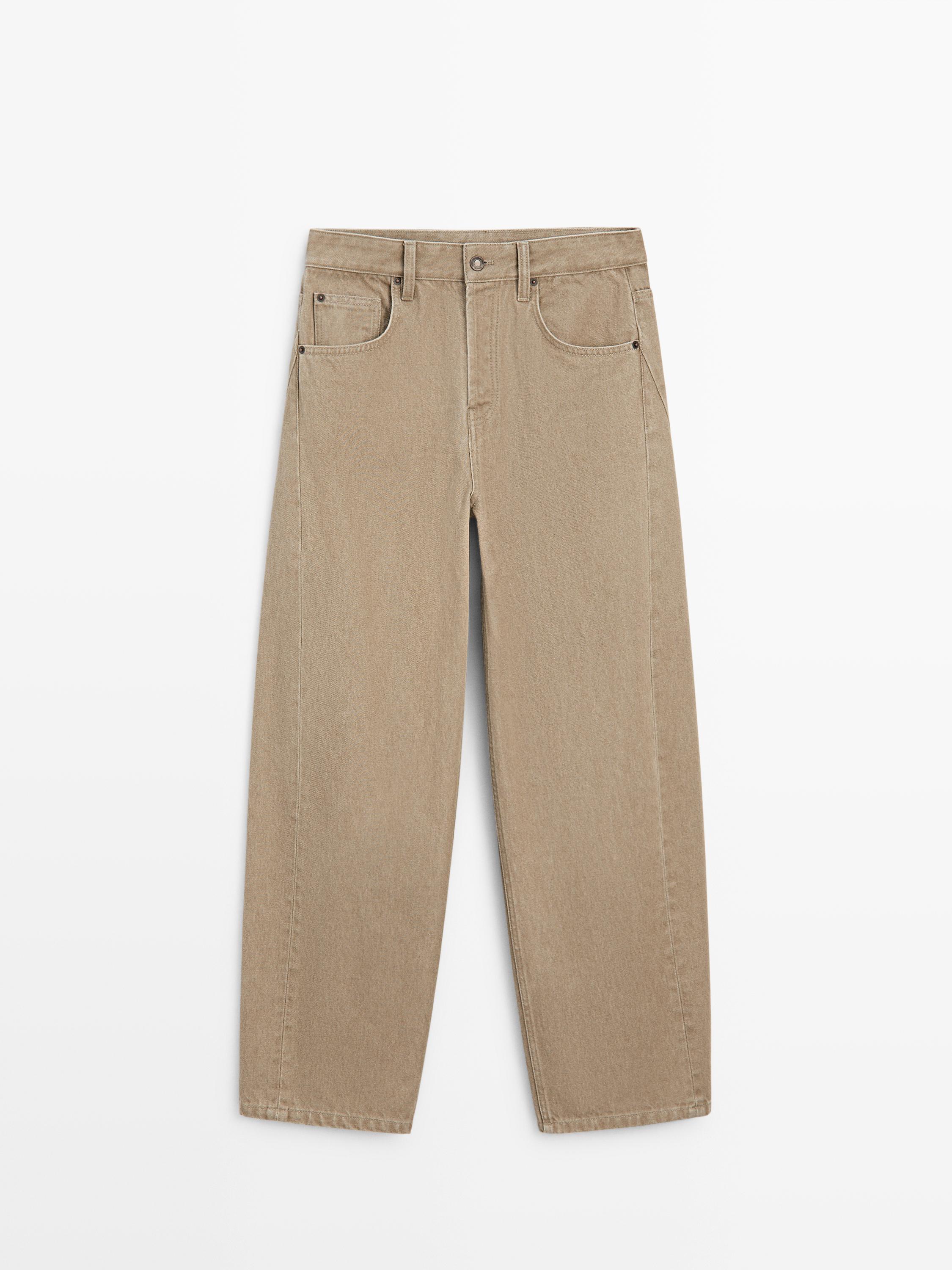 Vooraanzicht van een zandkleurige ballonbroek met middelhoge taille, voor- en achterzakken, knoop- en ritssluiting.