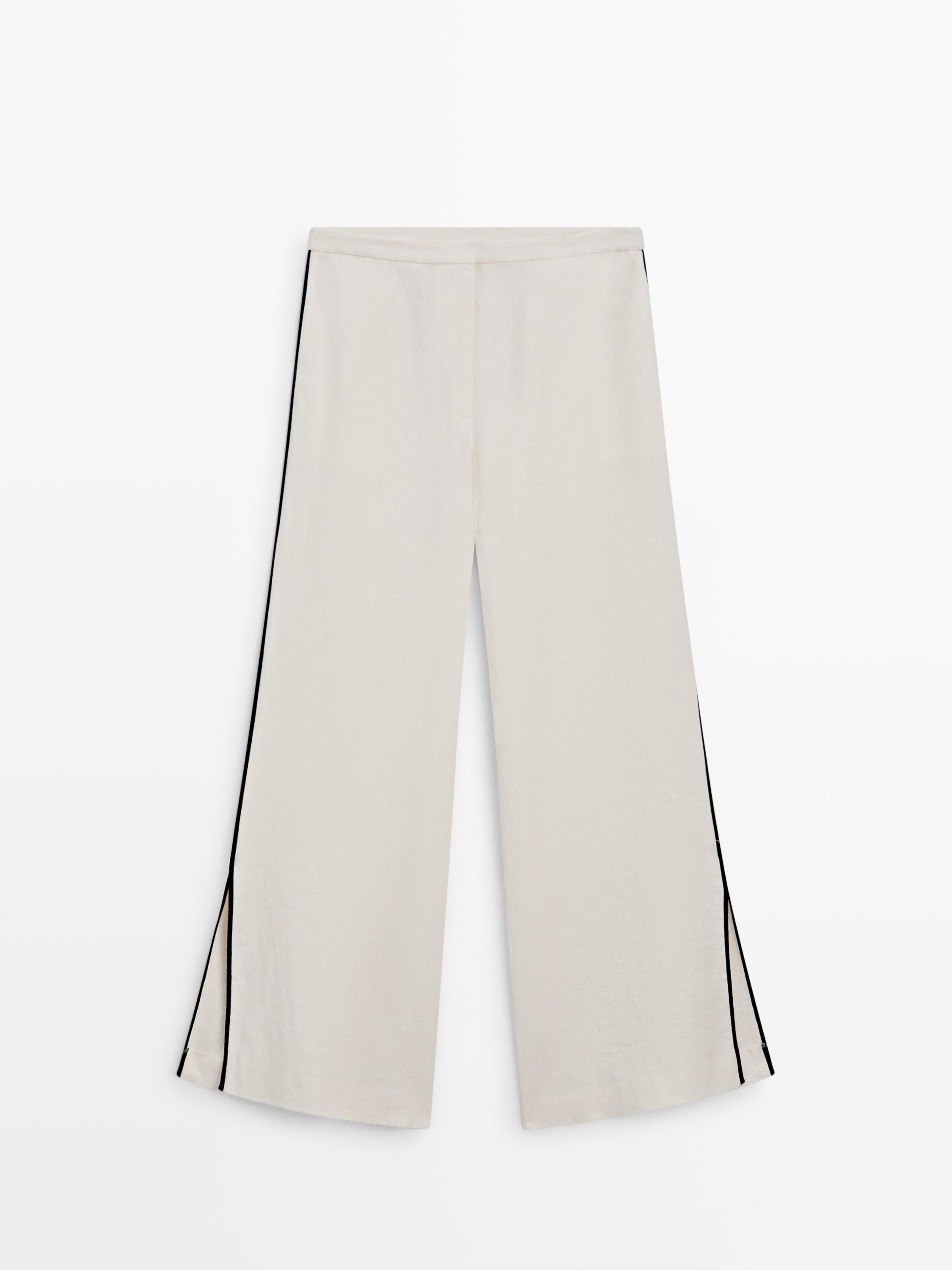 Front view of raw wide-leg pants with black stripes on the sides.