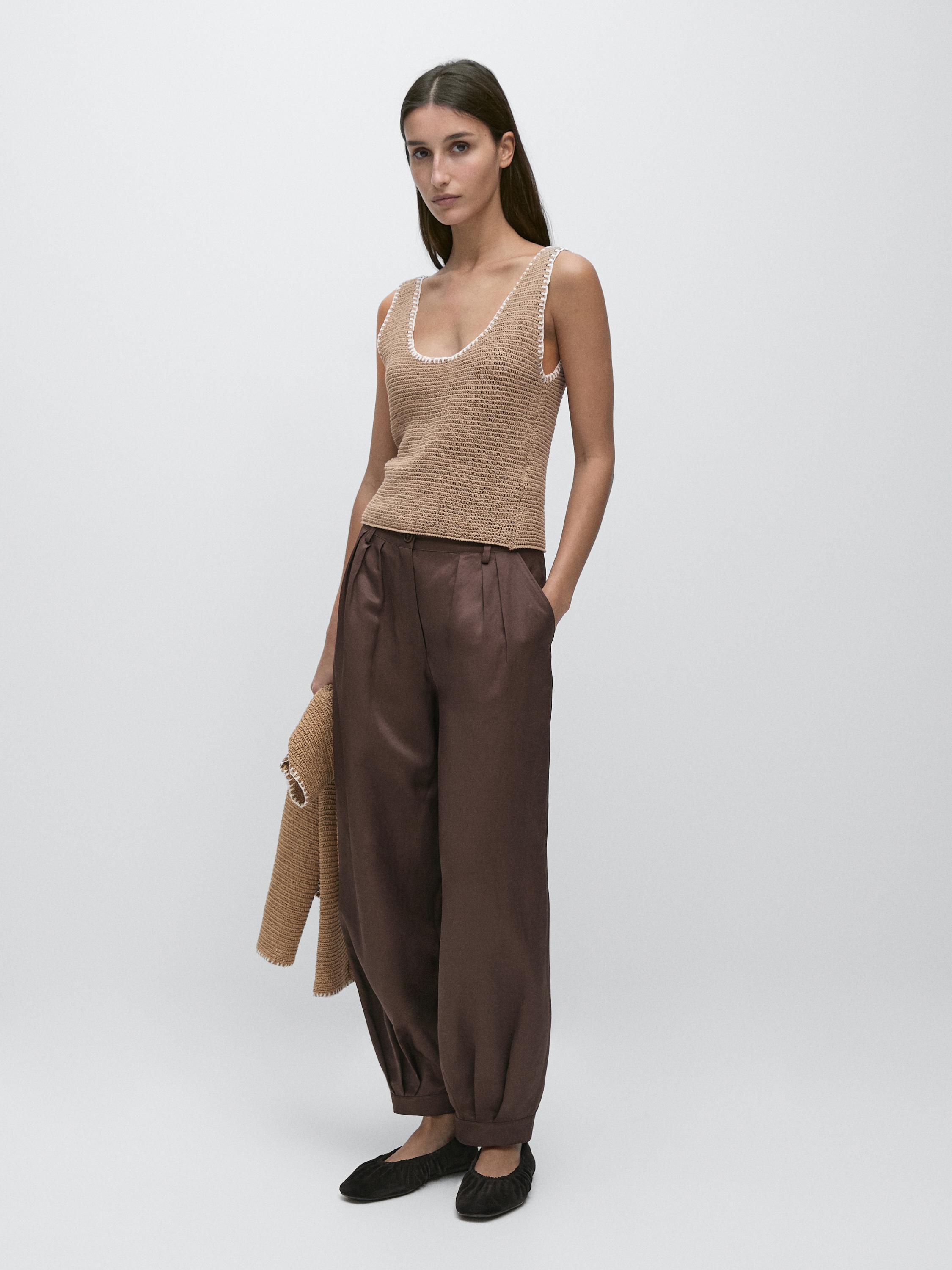 Conjunto de top camel sin mangas y pantalones marrones sueltos con pinzas.