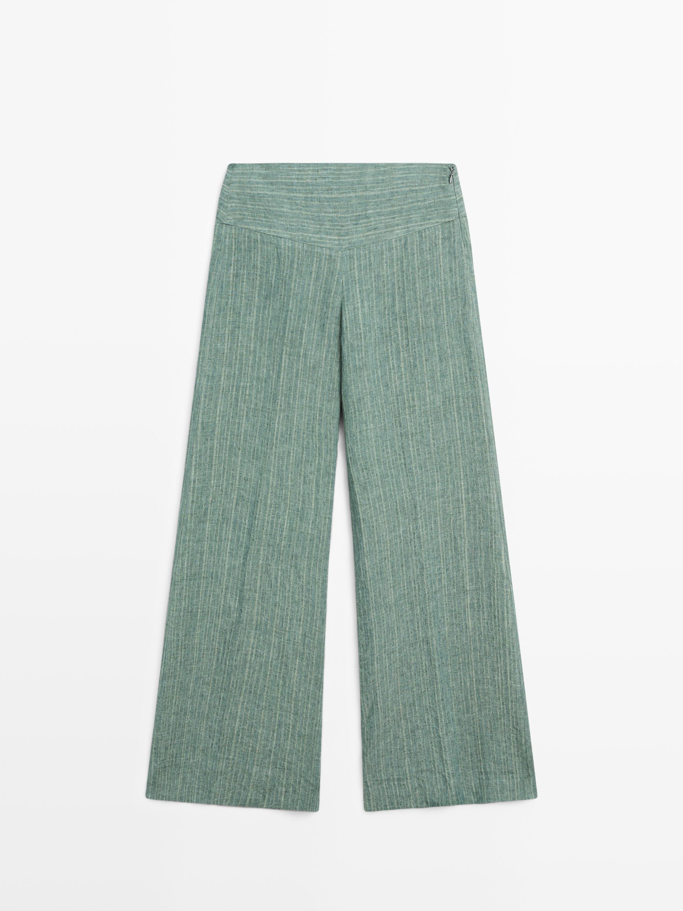 Vista frontal de pantalón fluido verde agua con rayas verticales y fajín.