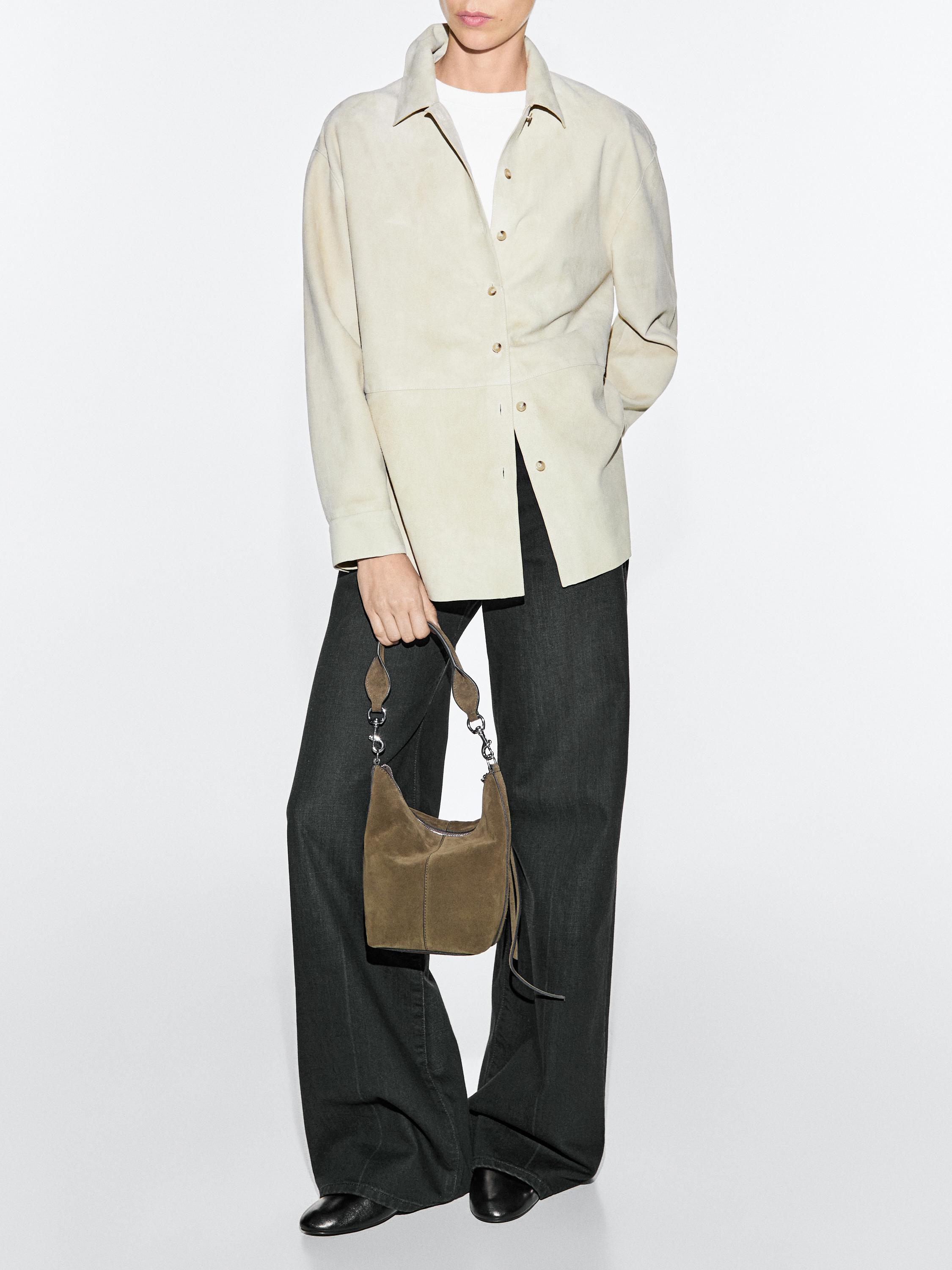 Beige button-down shirt set, dark wide-leg pants, and small khaki bag with a short handle.