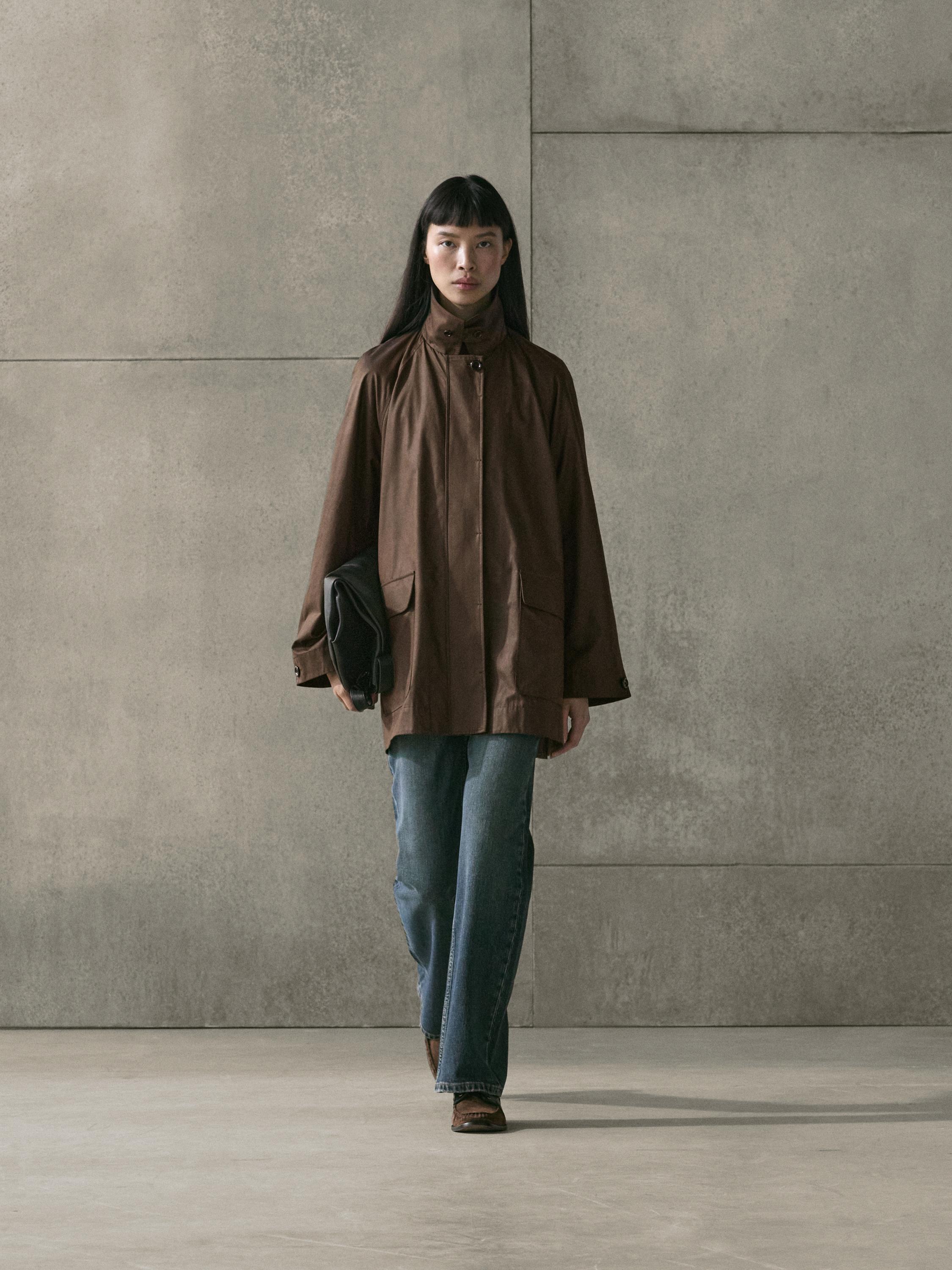 Taupe coat set with front pockets and wide-leg blue jeans.