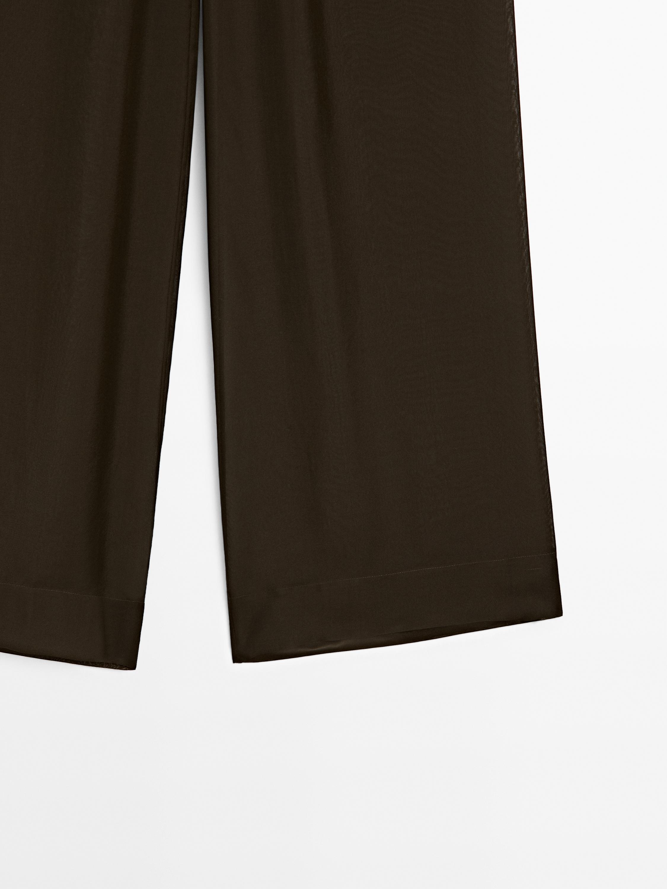 Close-up of dark wide-leg trousers.