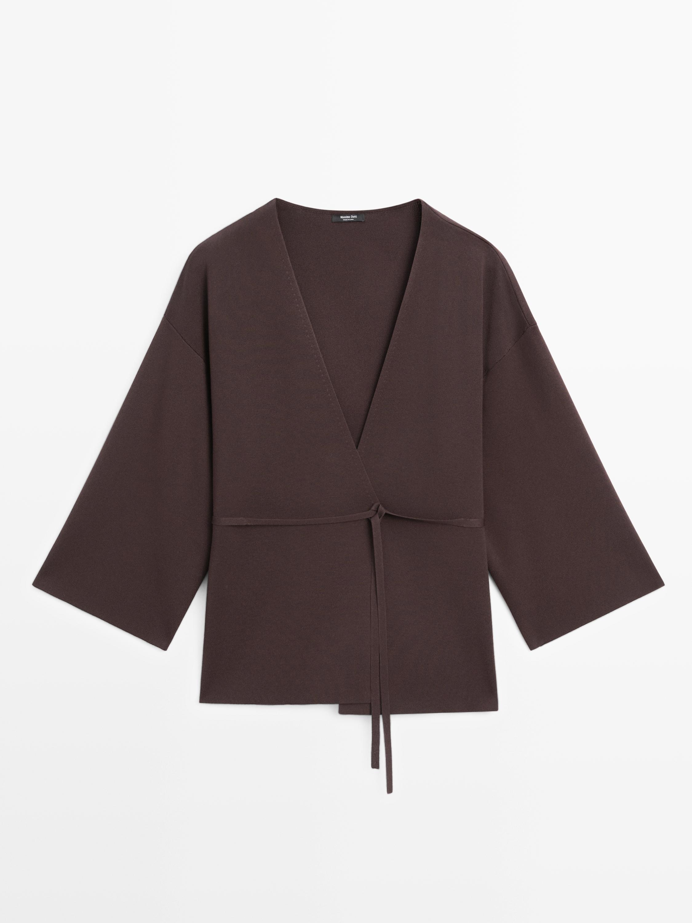 Widok z przodu brązowego kardiganu typu kimono z szerokimi rękawami i cienkim paskiem.