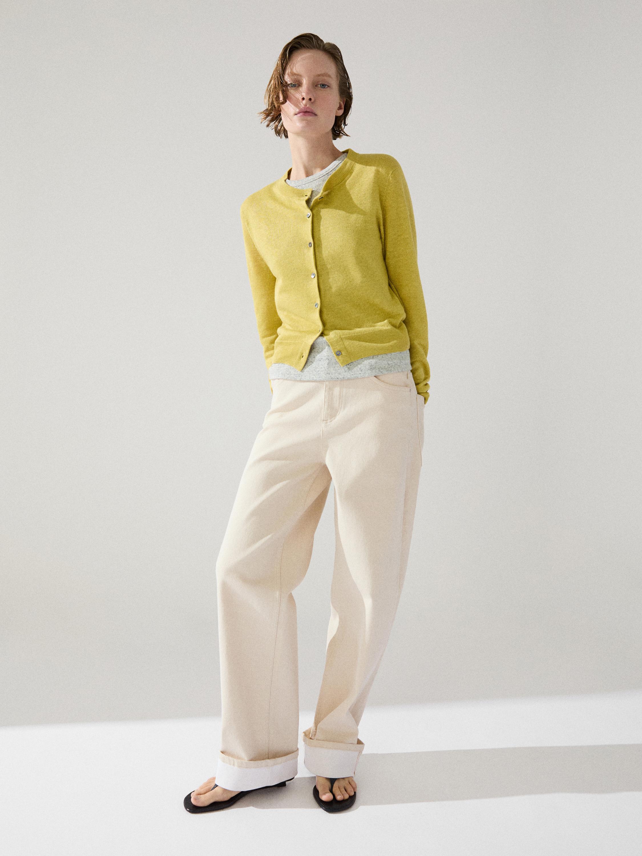 Conjunto de cárdigan lima con botones y pantalones anchos beige con dobladillo.