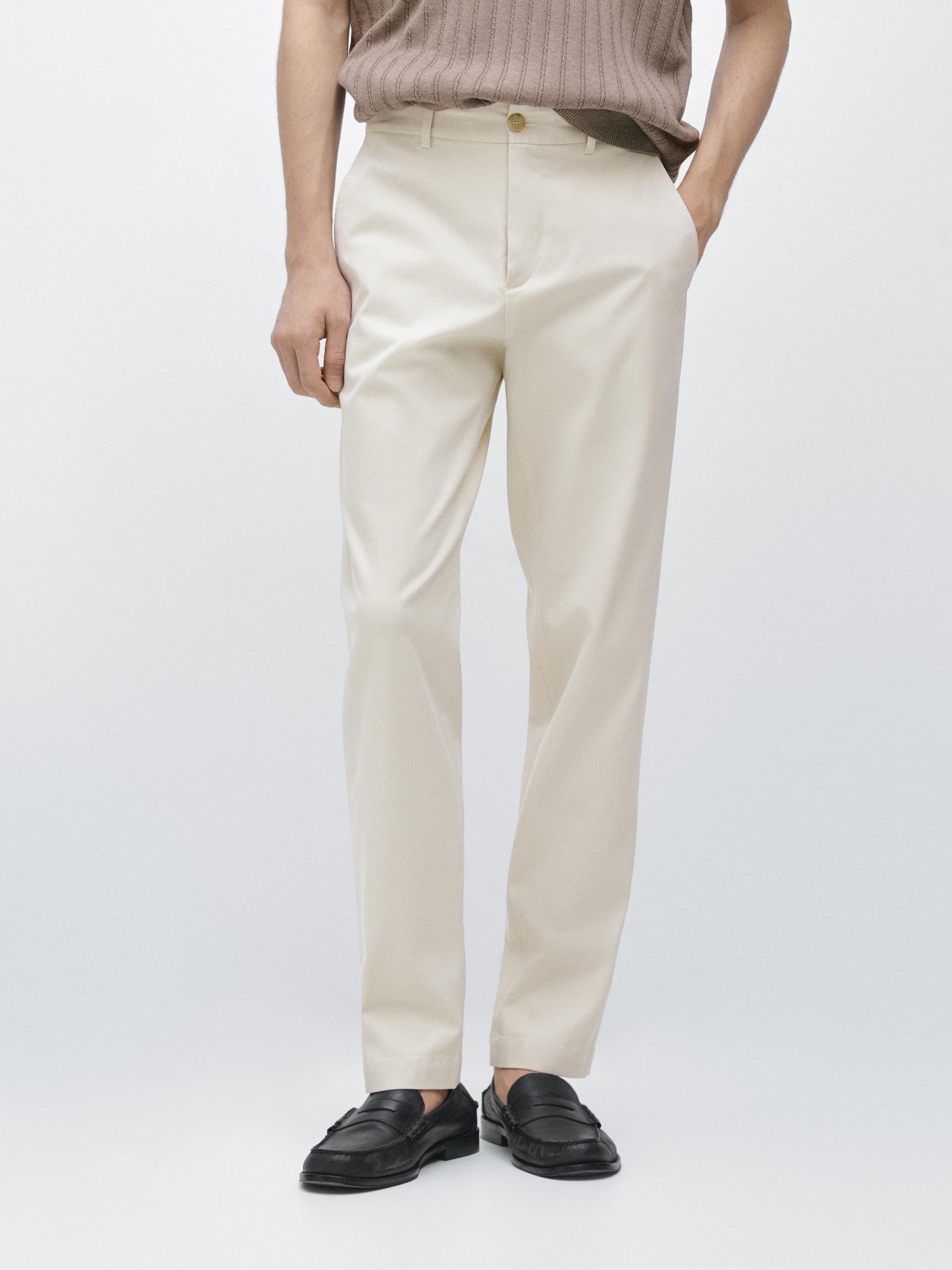 Conjunt de pantaló beix tapered fit amb butxaques laterals i botó frontal, combinat amb mocassins negres.