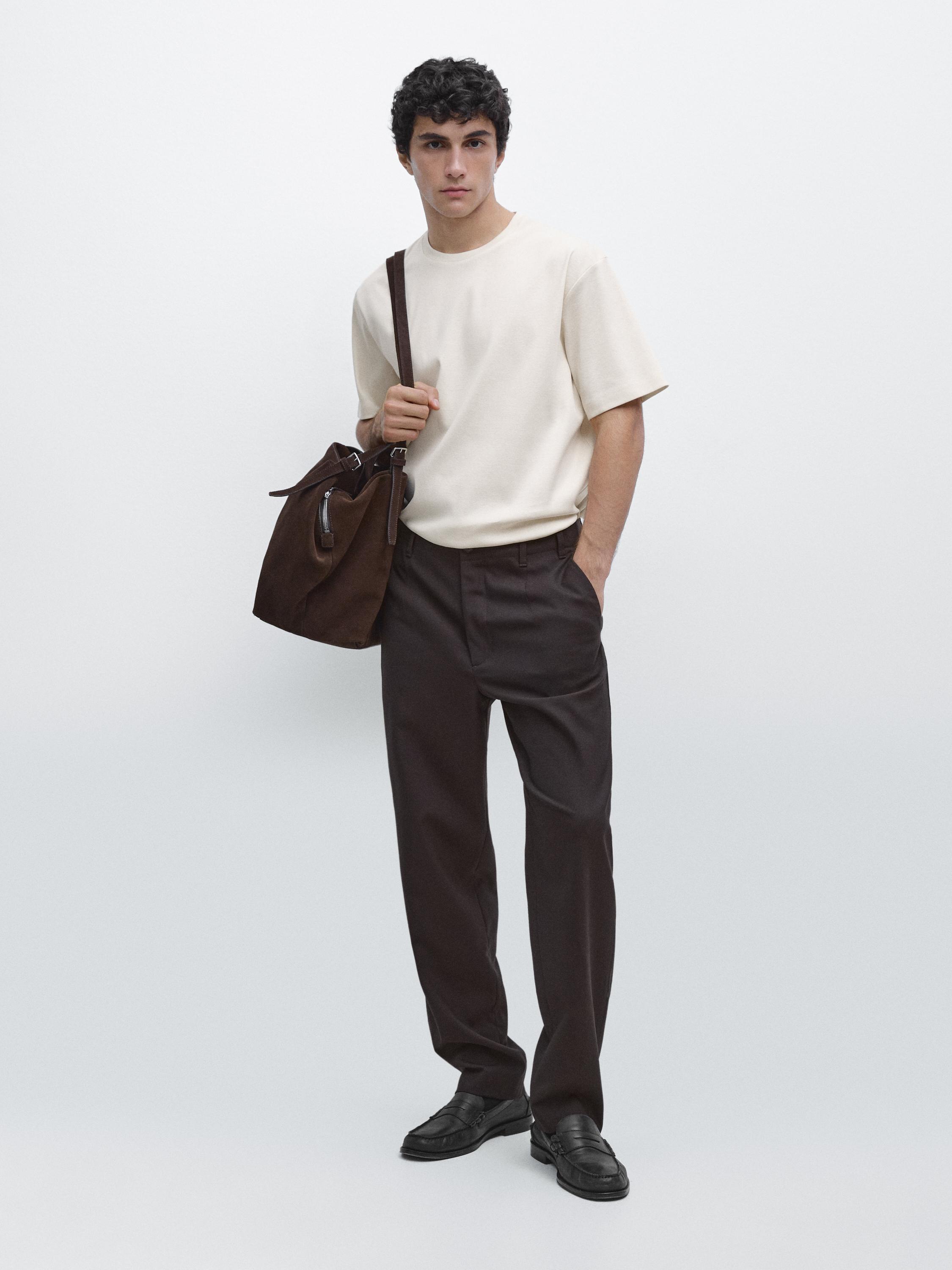 Raw short-sleeve T-shirt and dark pants set. Visible side pocket. Black shoes.
