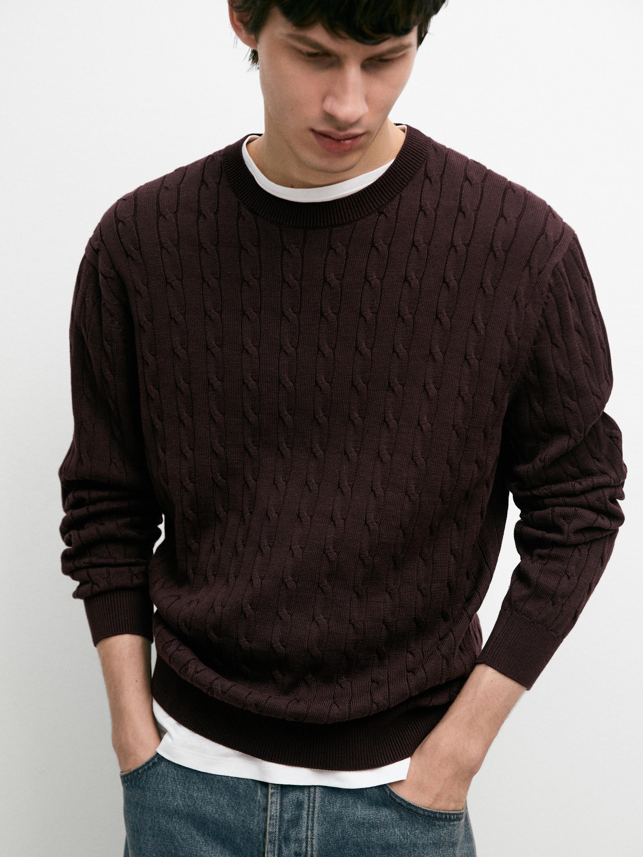 Conxunto de xersei burdeos de punto trenzado con colo redondo e puños axustados, sobre camiseta branca.