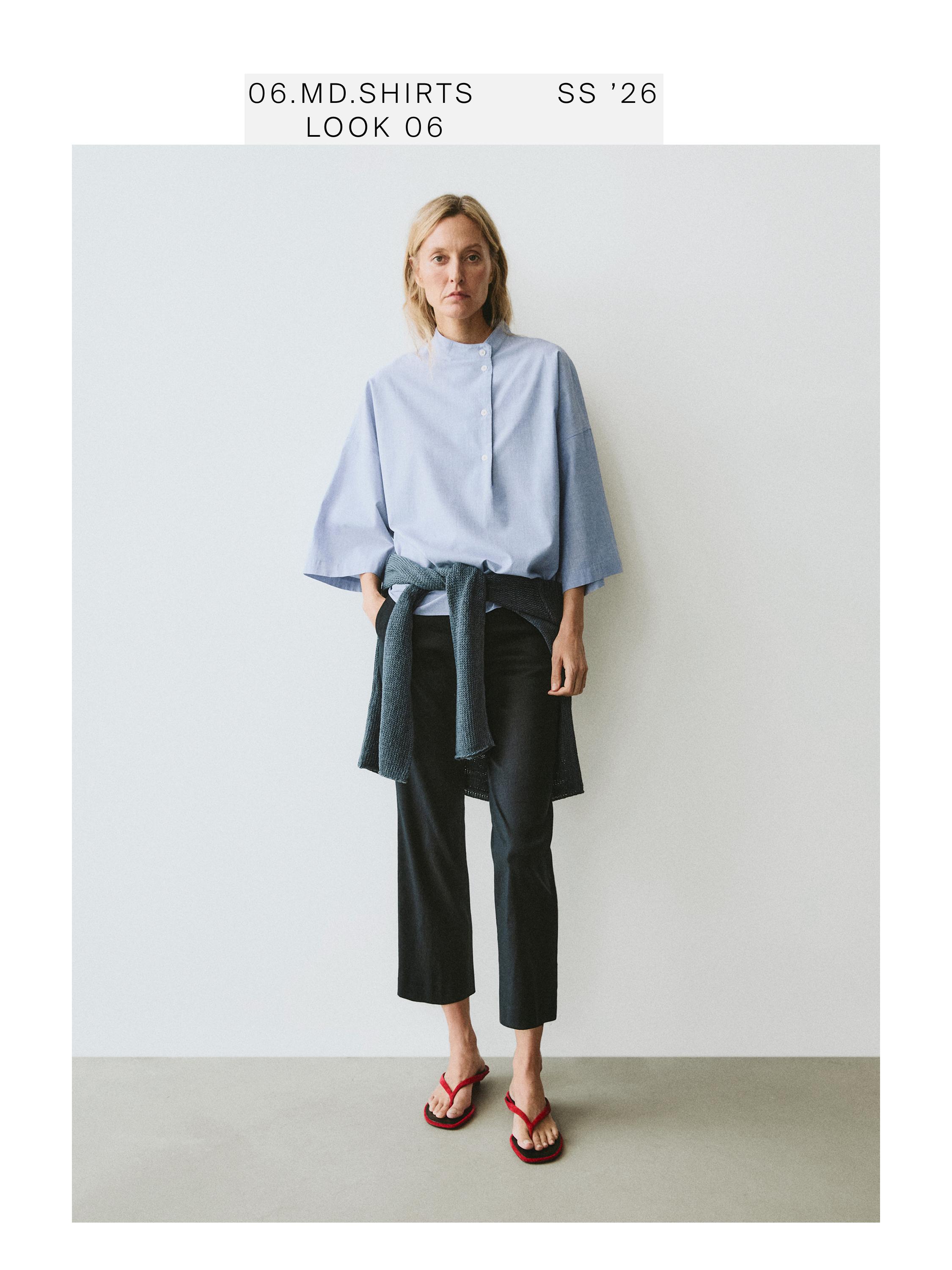 Denim blue button-down blouse set with dark pants and red sandals. Visible text: "06.MD.SHIRTS SS '26 LOOK 06".
