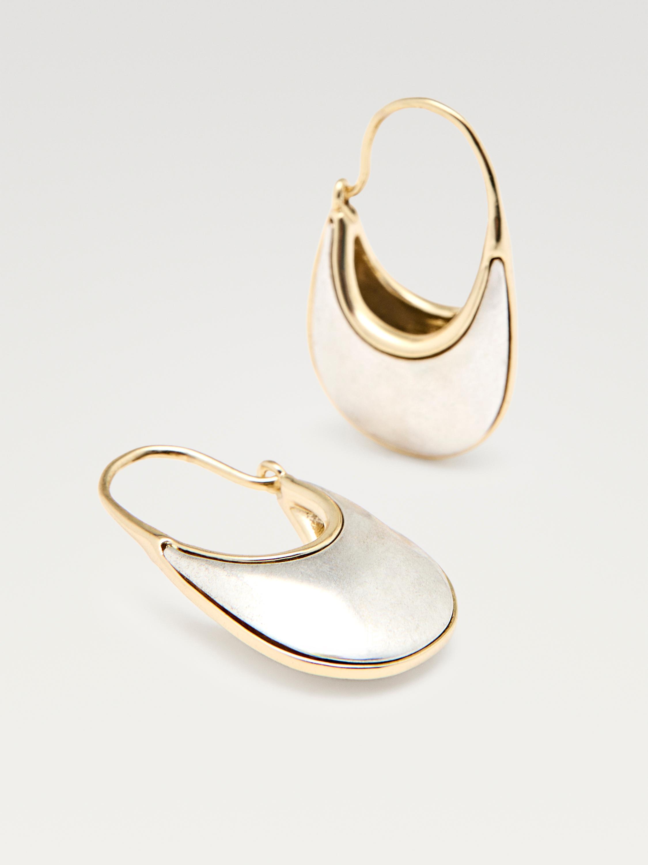 Silver-colored hoop earrings with a curved design and gold edge.