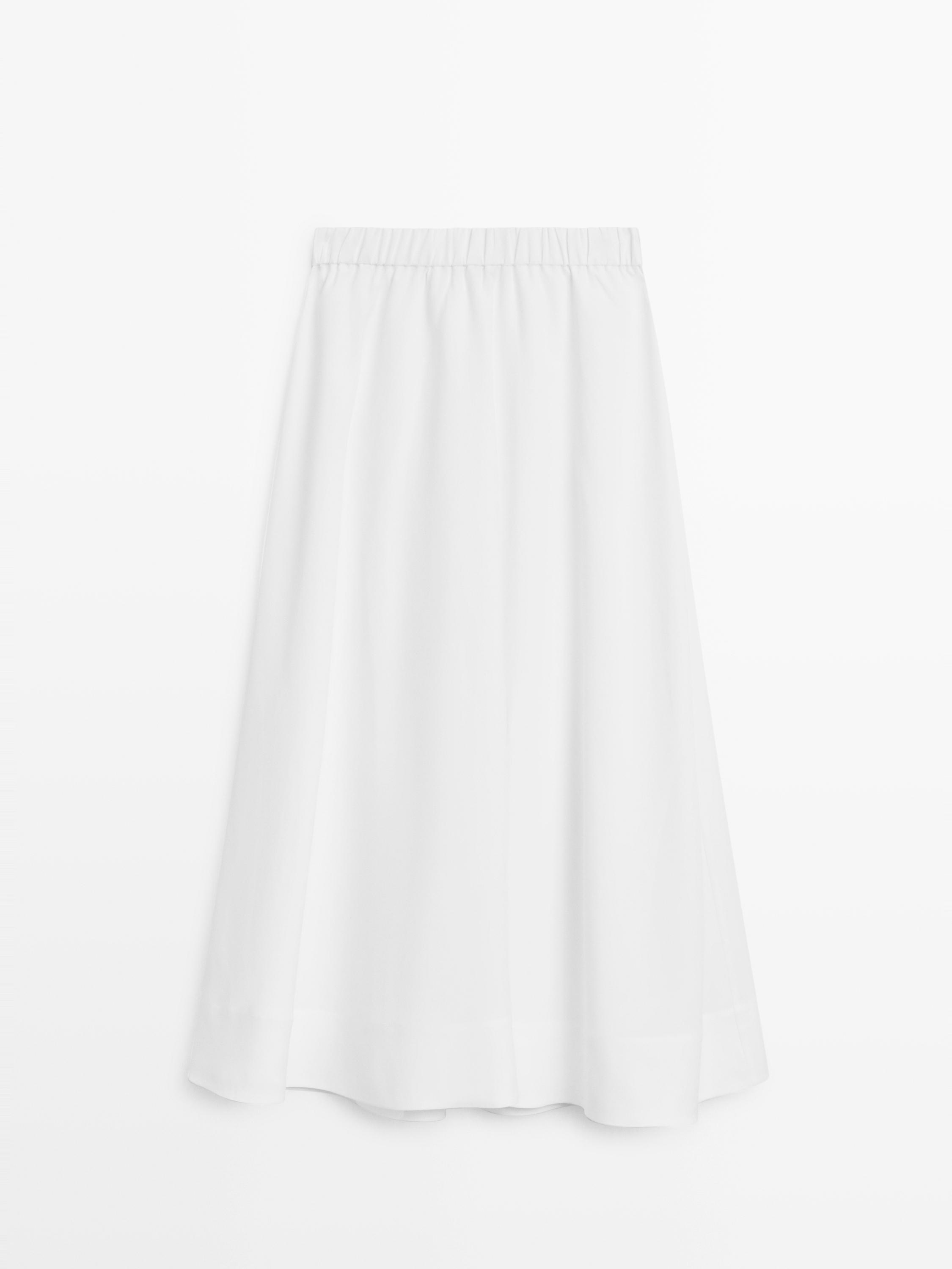 Front view of a flowing white midi skirt with an elastic waistband.