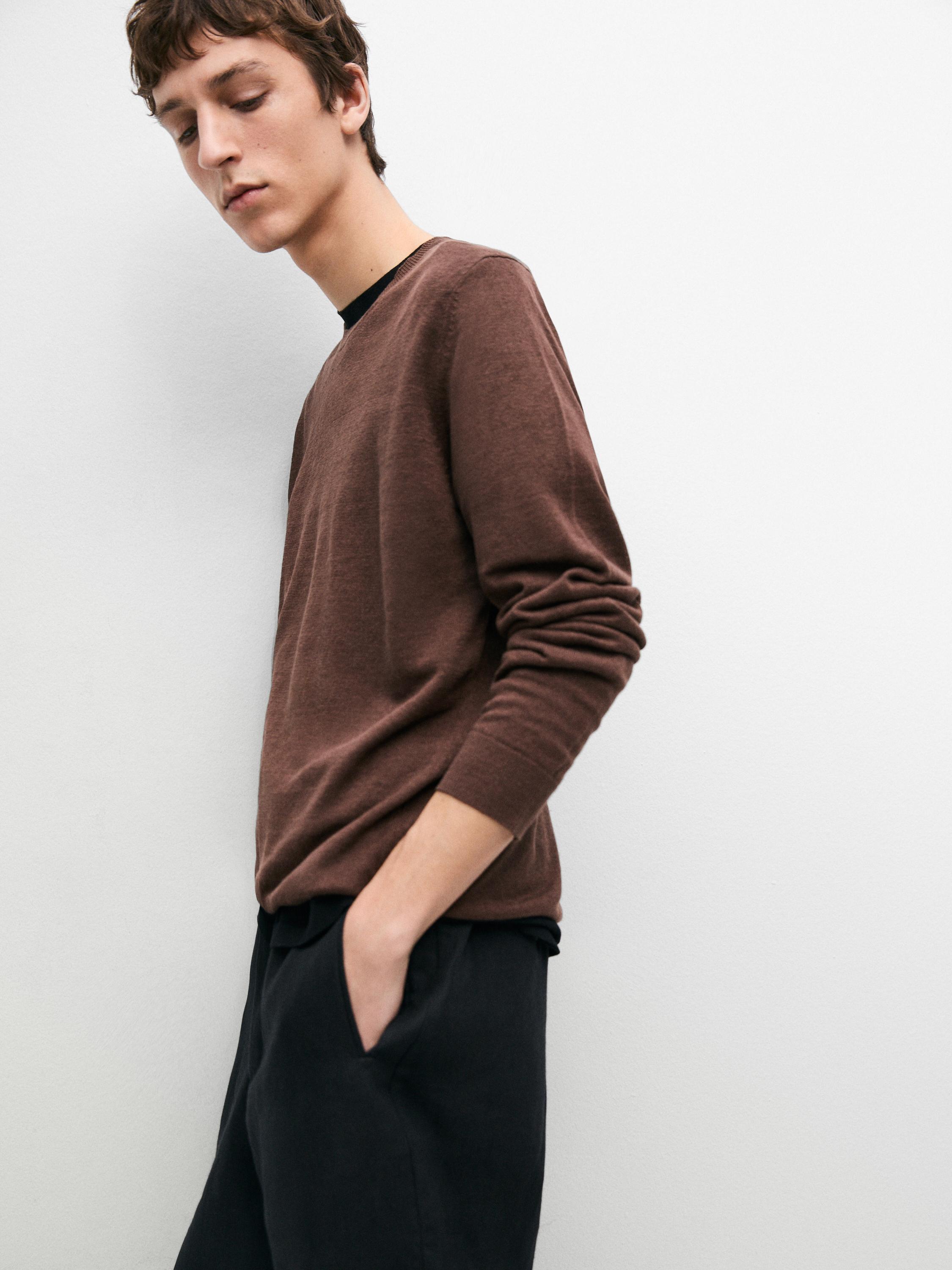 Plano medio de jersey café rojizo con cuello redondo y mangas largas.