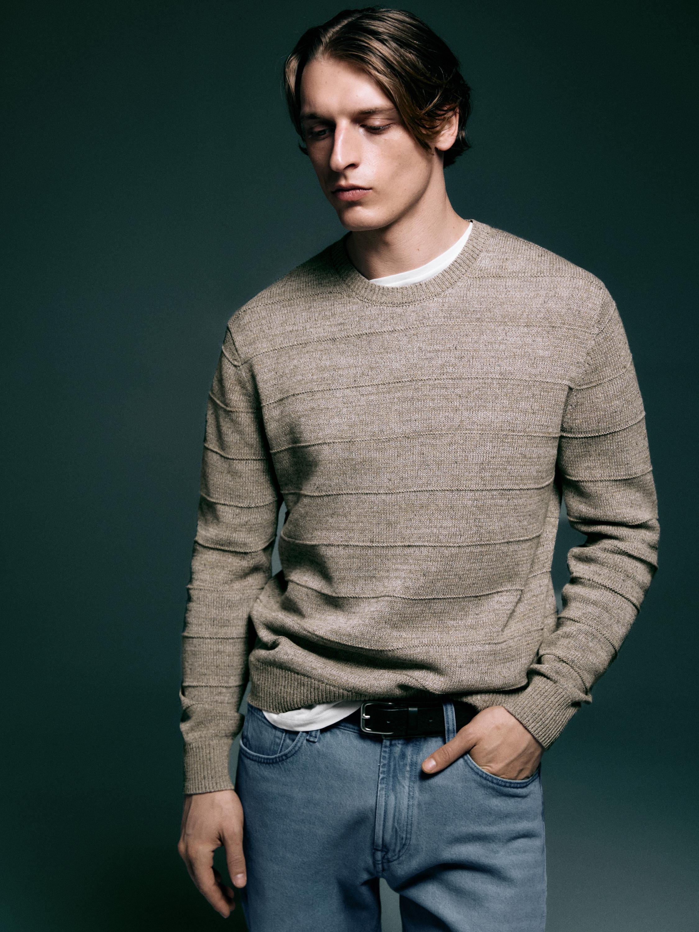 Conjunto de jersey visón de rayas con cuello redondo y jeans azules.