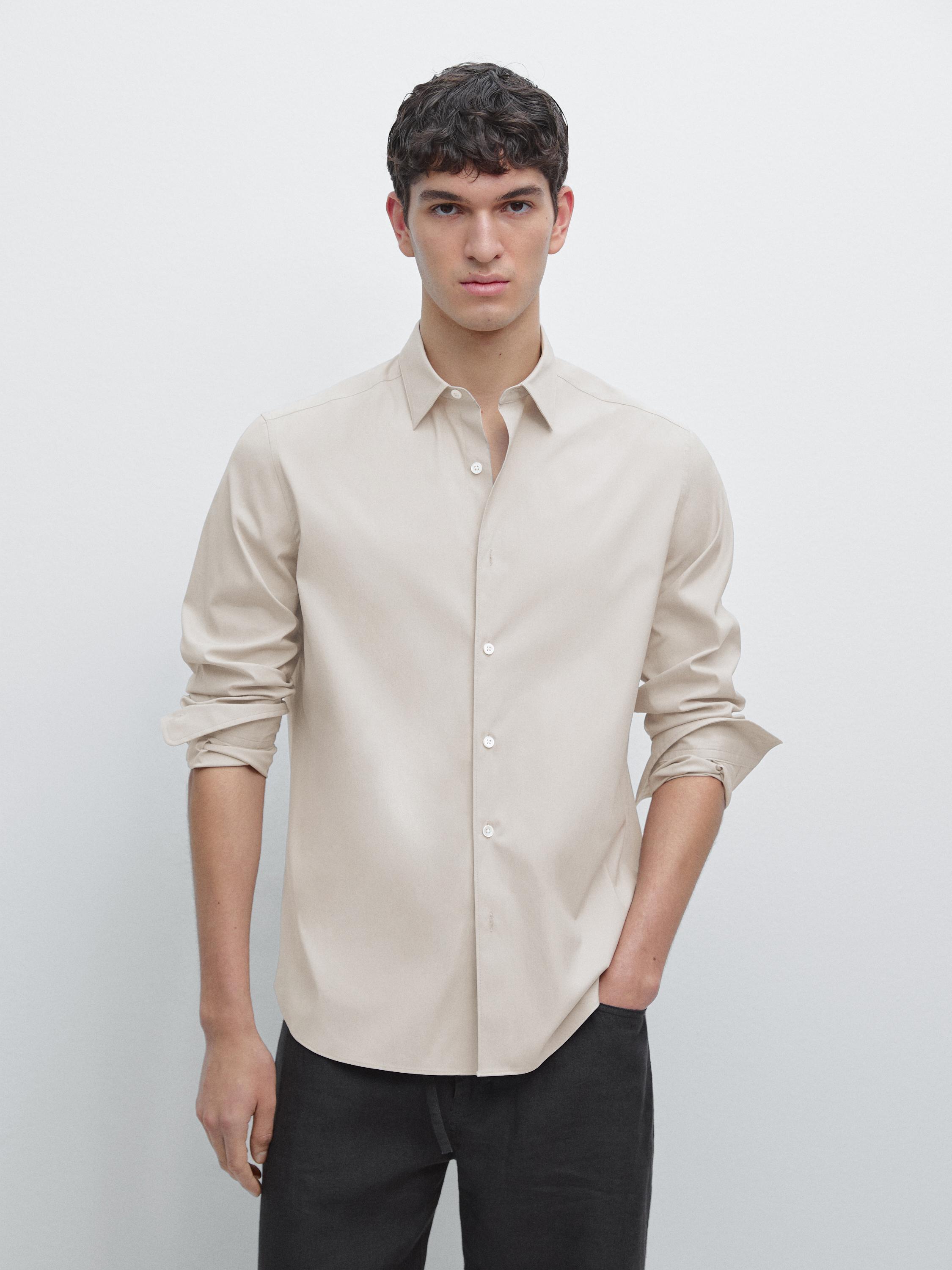 طقم قميص بيج بقصة عادية مع أزرار أمامية وبنطلون غامق.