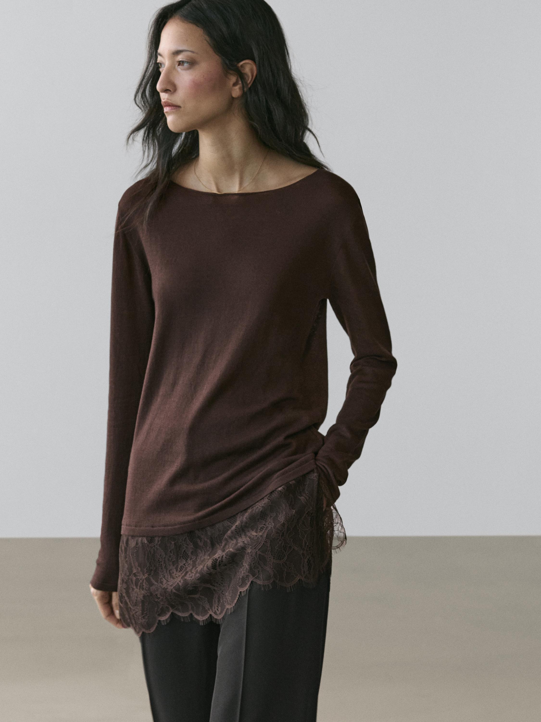 Zestaw składający się z brązowej koszulki z długim rękawem z koronkowym detalem u dołu i czarnych spodni.