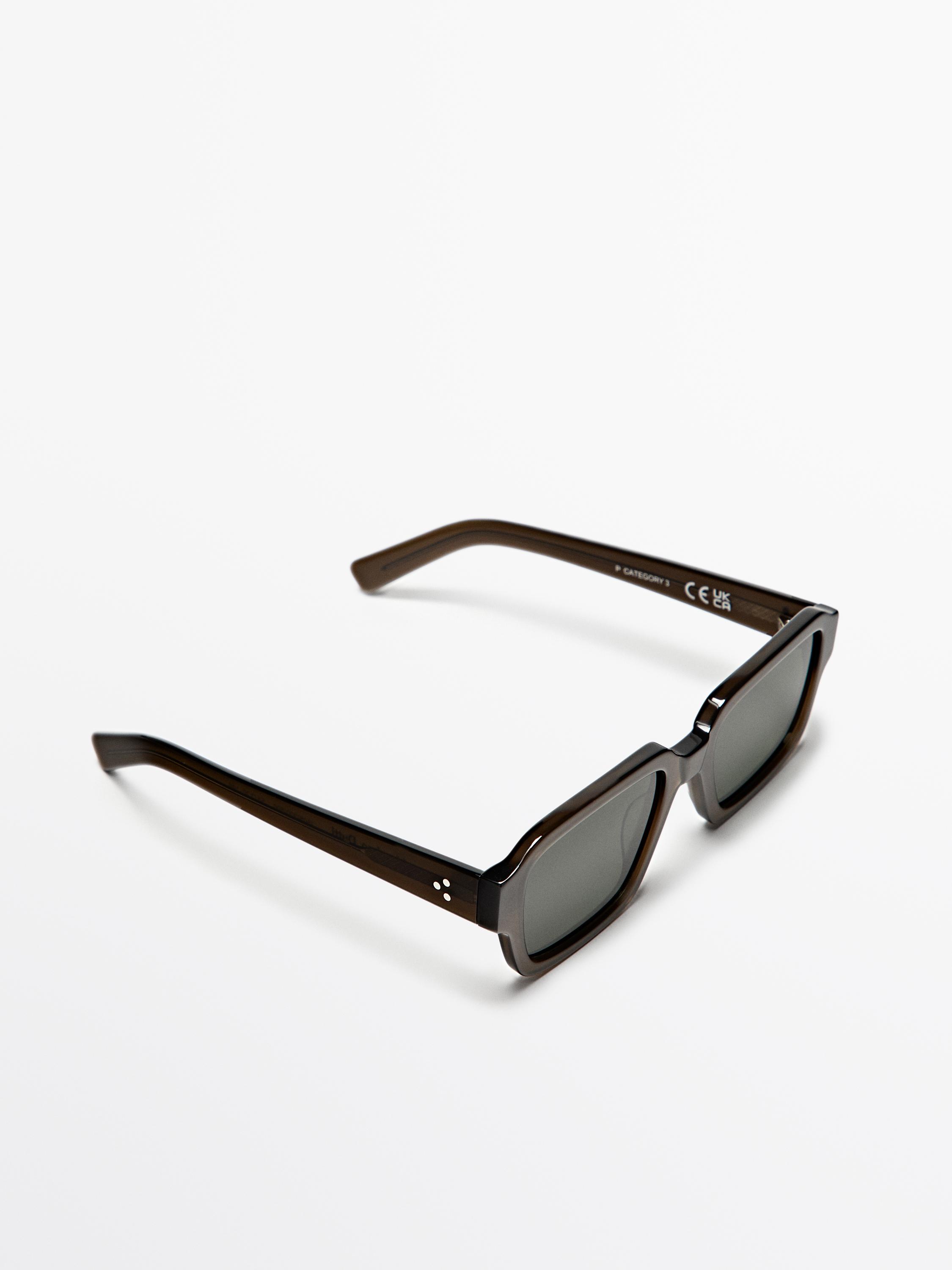 Kare çerçeveli ve kalın saplı yeşil güneş gözlüğü.