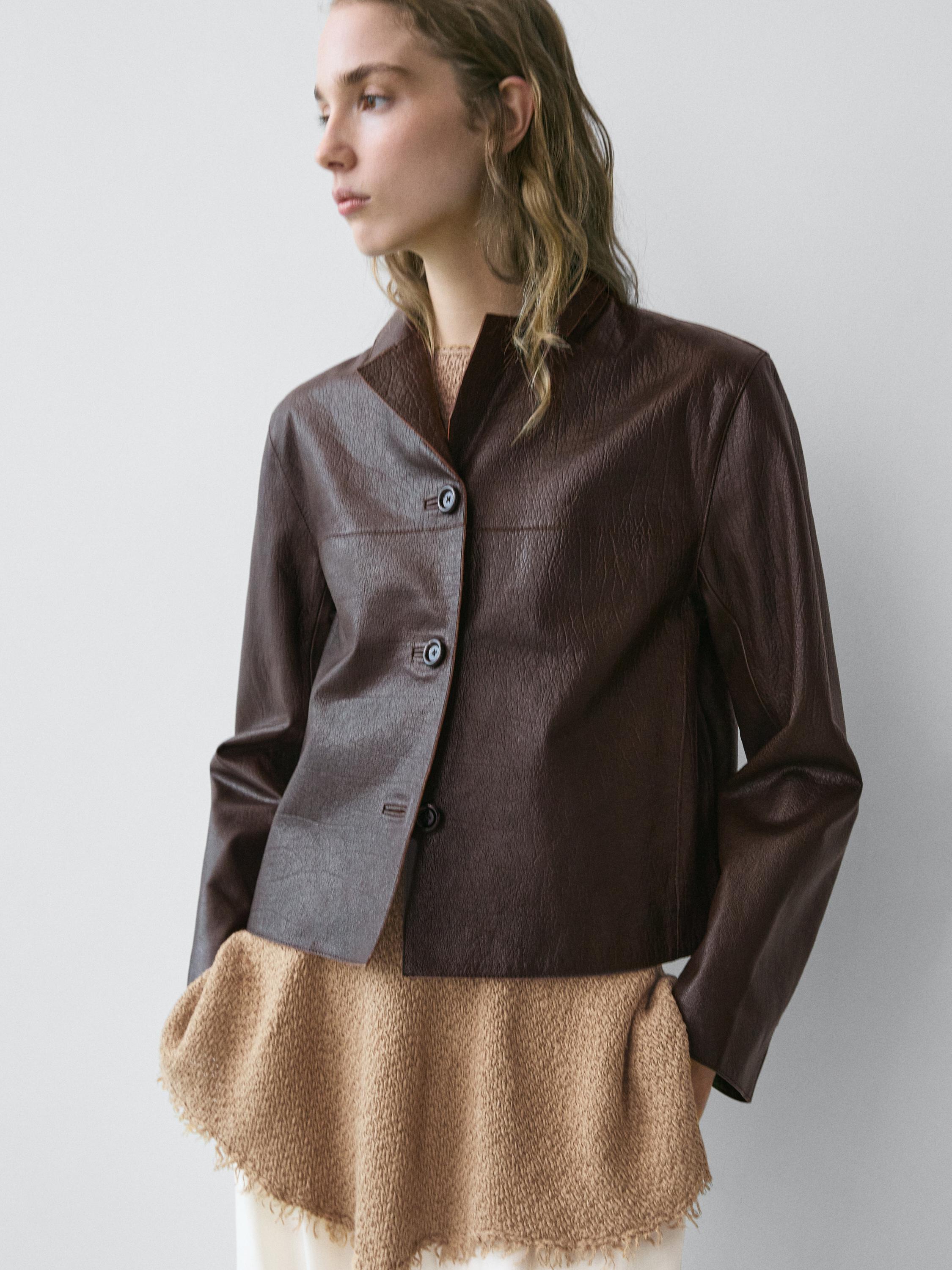 Medium shot of a brown cropped jacket with front buttons and a high collar.