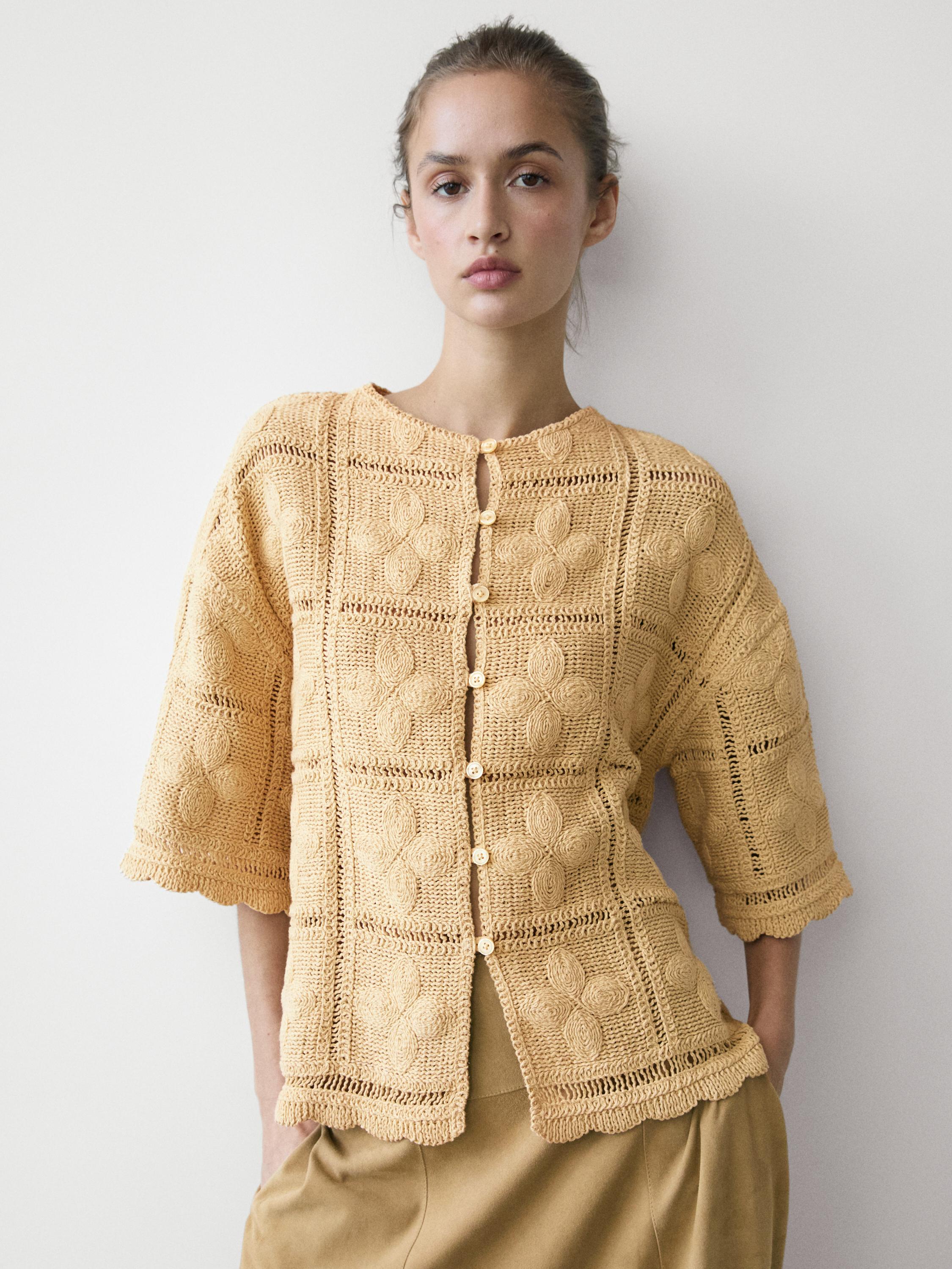 Conjunto de chaqueta vainilla de punto calado de crochet con botones frontales y mangas tres cuartos.