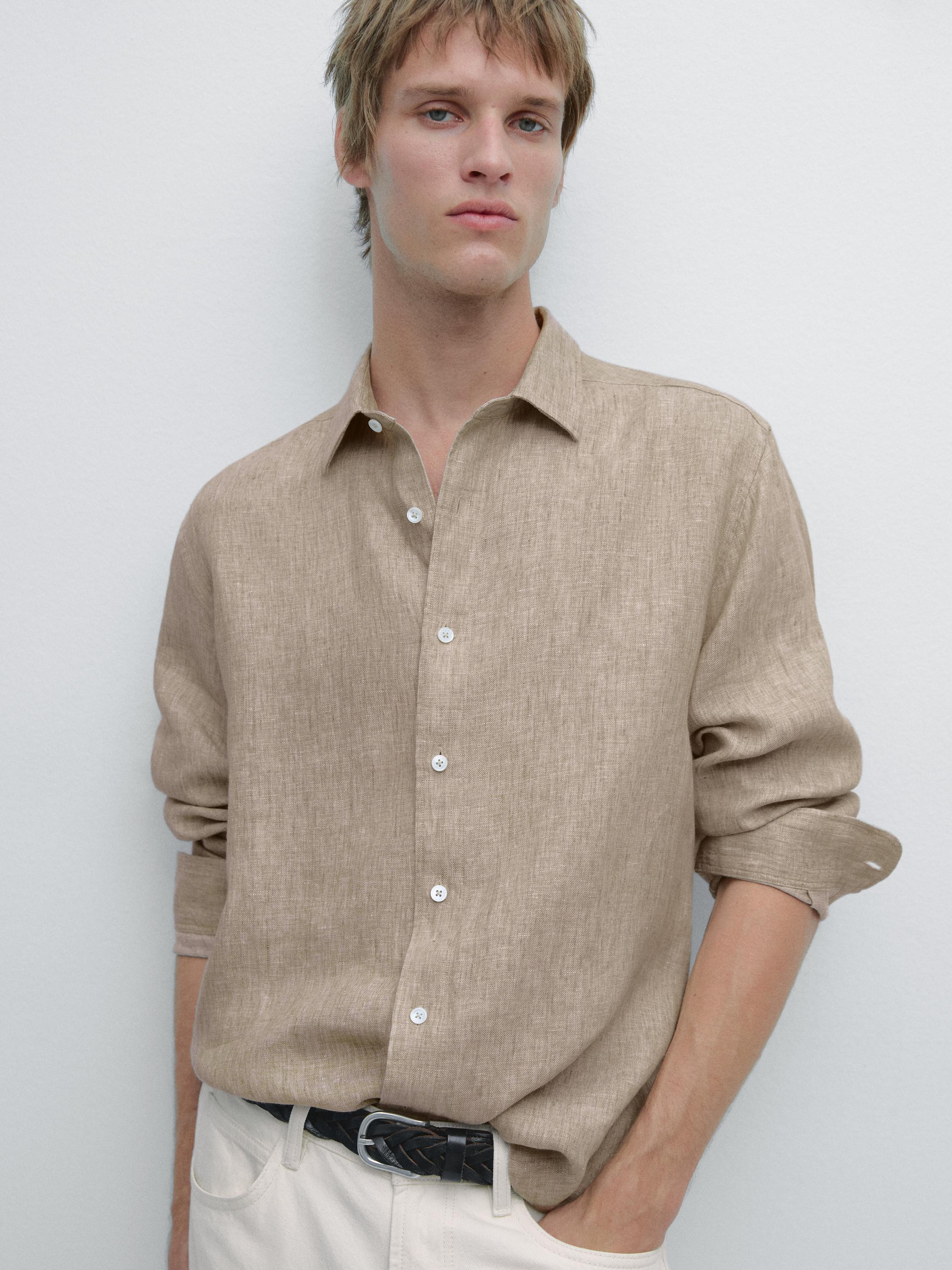 Средний план необработанной рубашки с длинными рукавами, белыми пуговицами и классическим воротником.