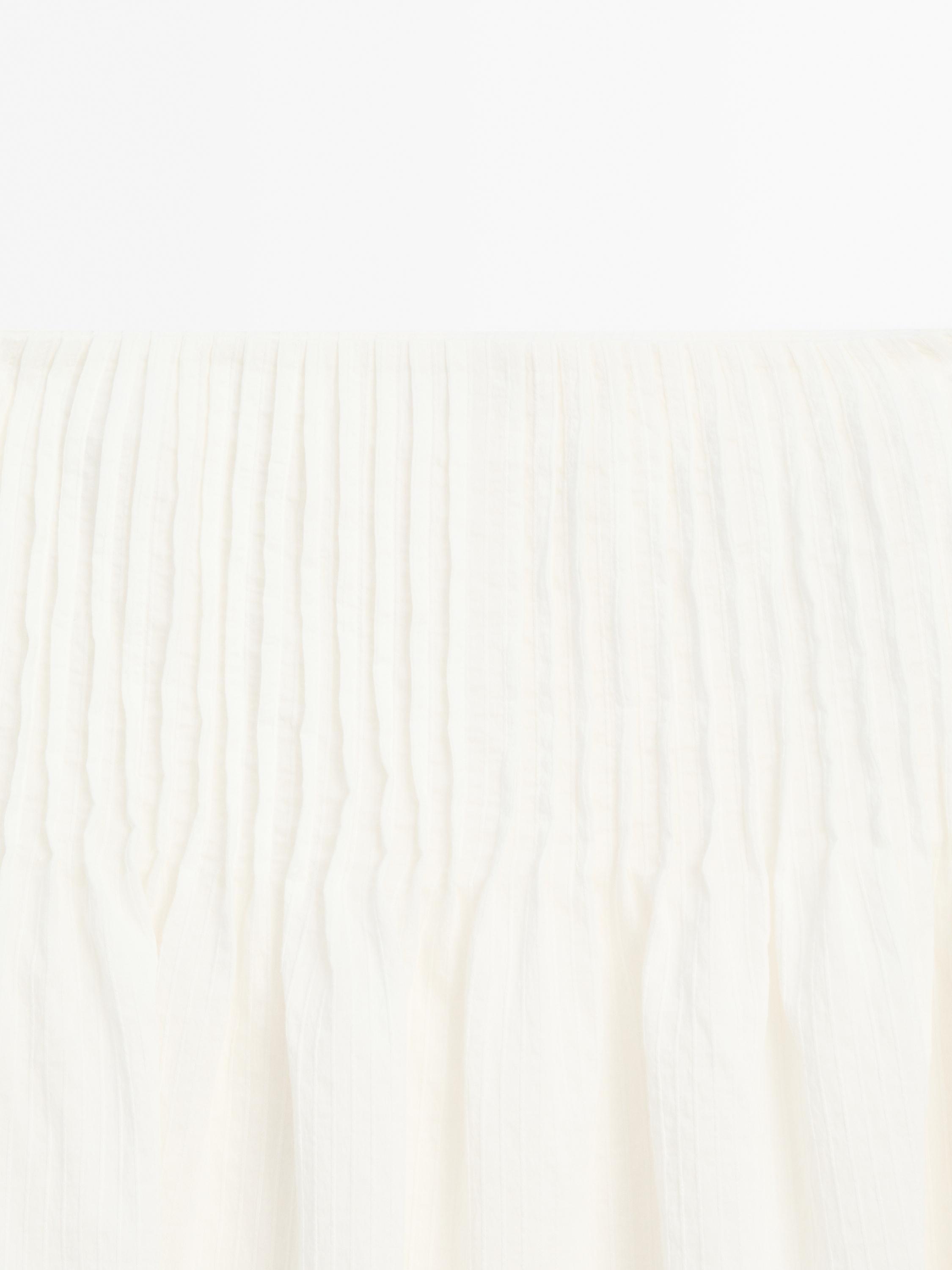 Long pleated skirt with fabric detail