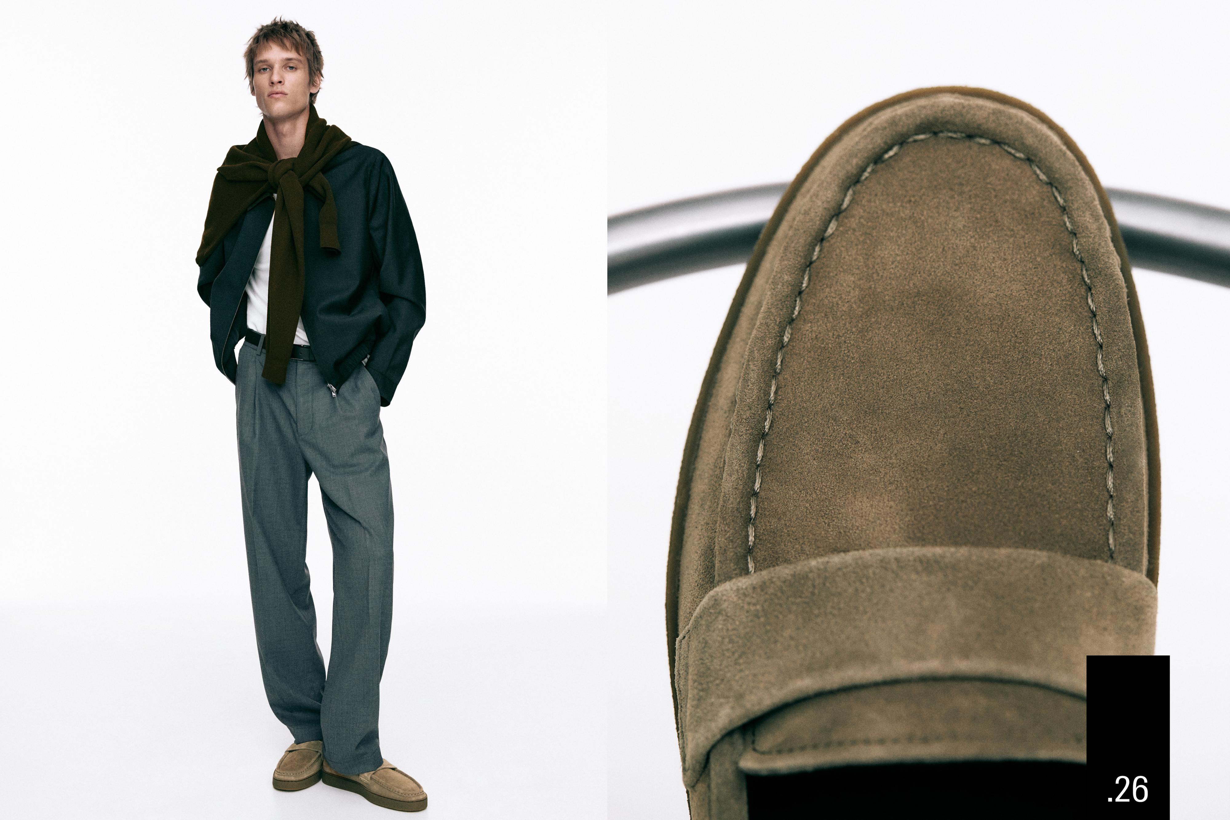 Komplet me këmishë blu, pantallona gri dhe mokasina kafe. Plan i afërt i mokasinit kafe me qepje të dukshme.