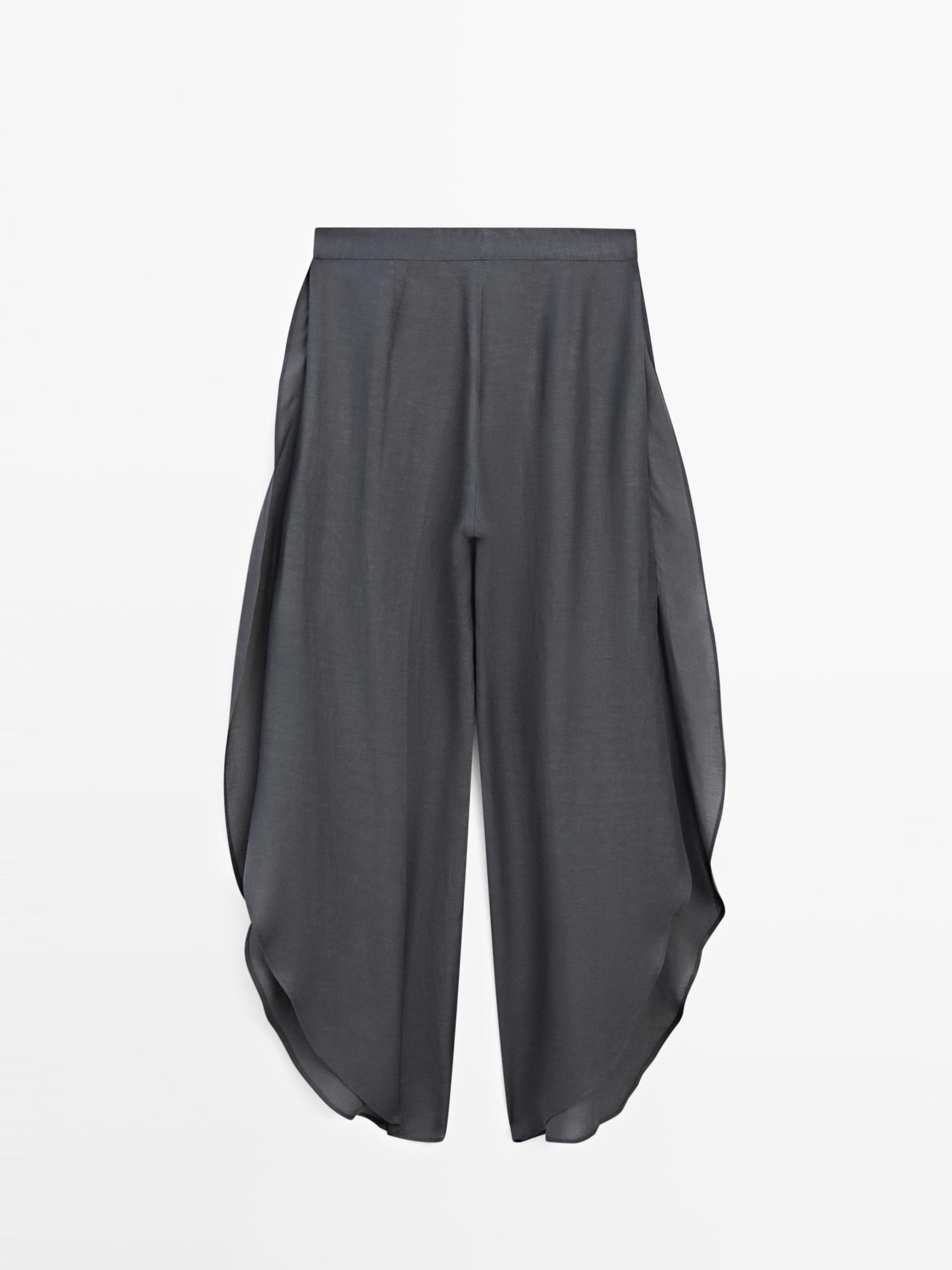 Vista frontal de pantalón gris antracita con aberturas laterales y corte amplio.