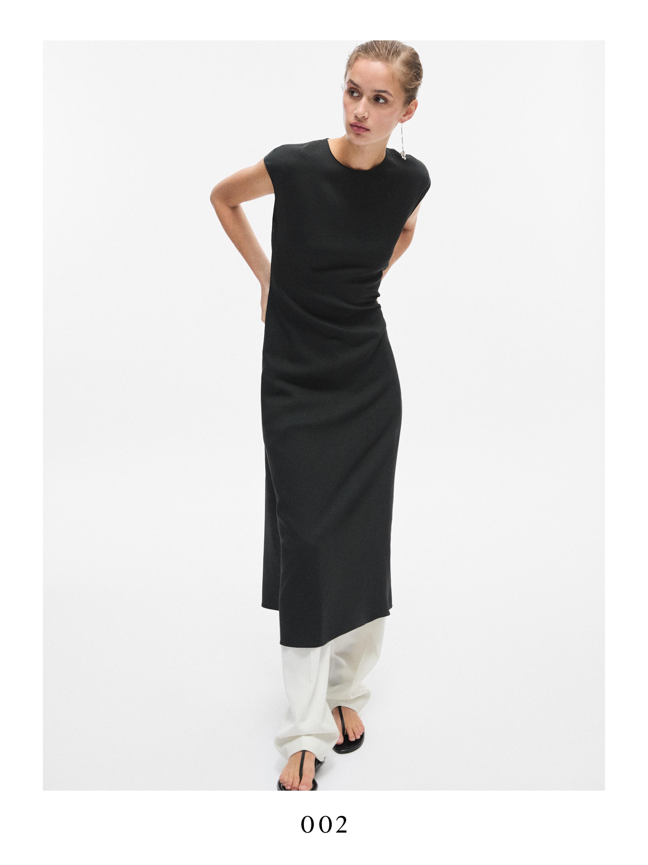 Σετ από αέρινο αμάνικο μαύρο φόρεμα και λευκό παντελόνι.