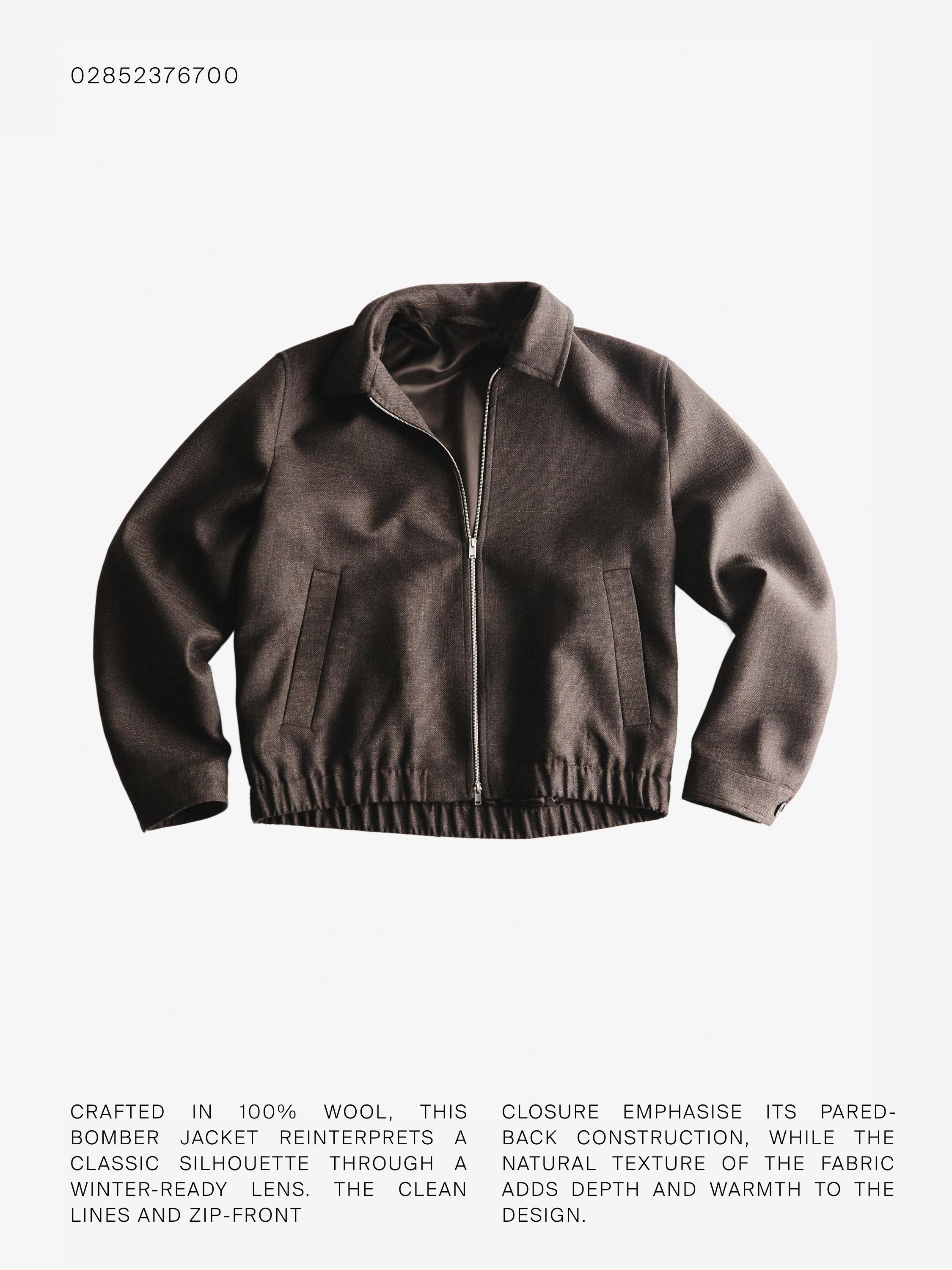 Priekšskats uz brūnu bomber jaku ar rāvējslēdzēju un sānu kabatām.