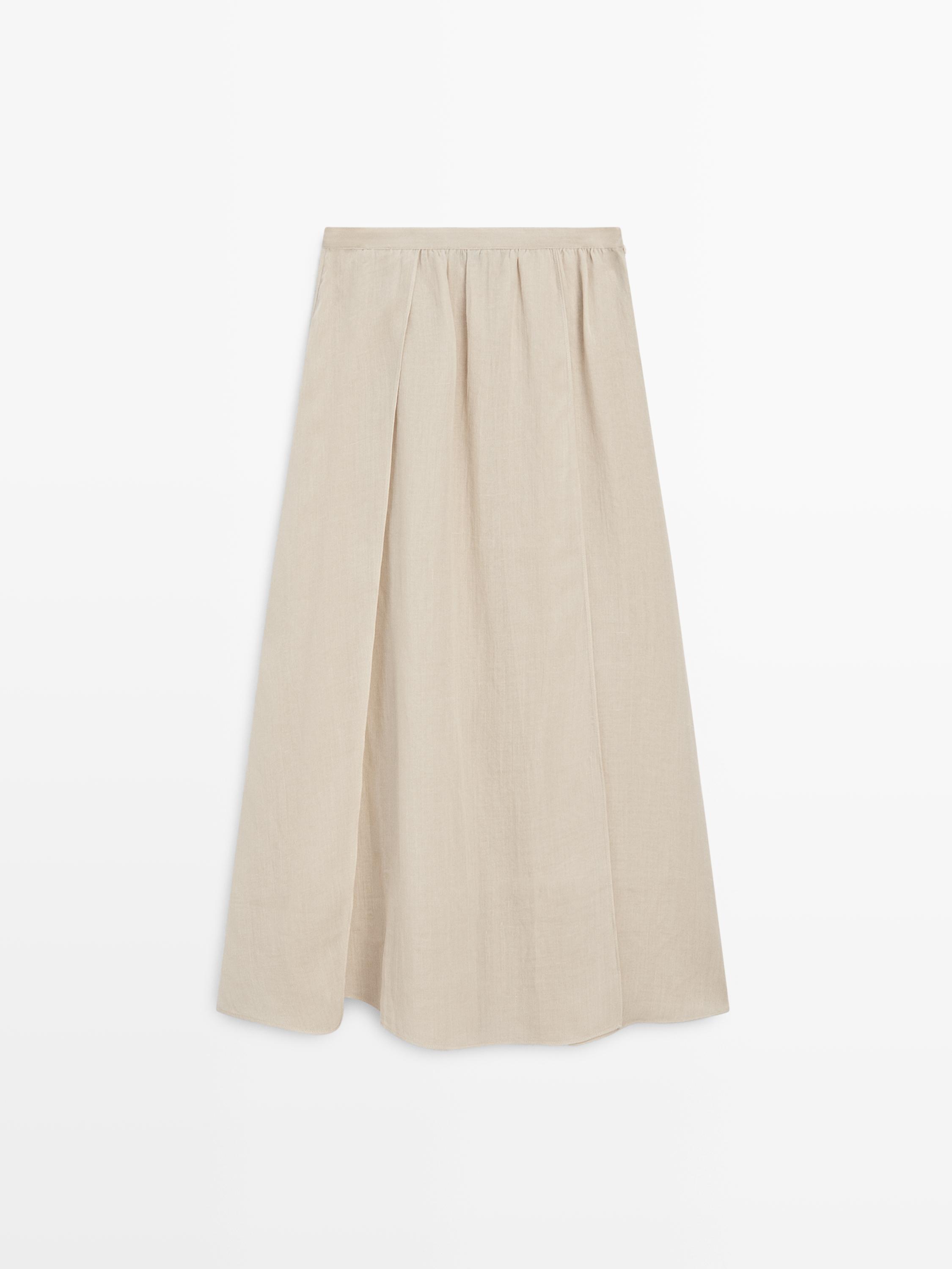 Krem rengi, dökümlü, pilili ve geniş kesimli midi eteğin önden görünümü.