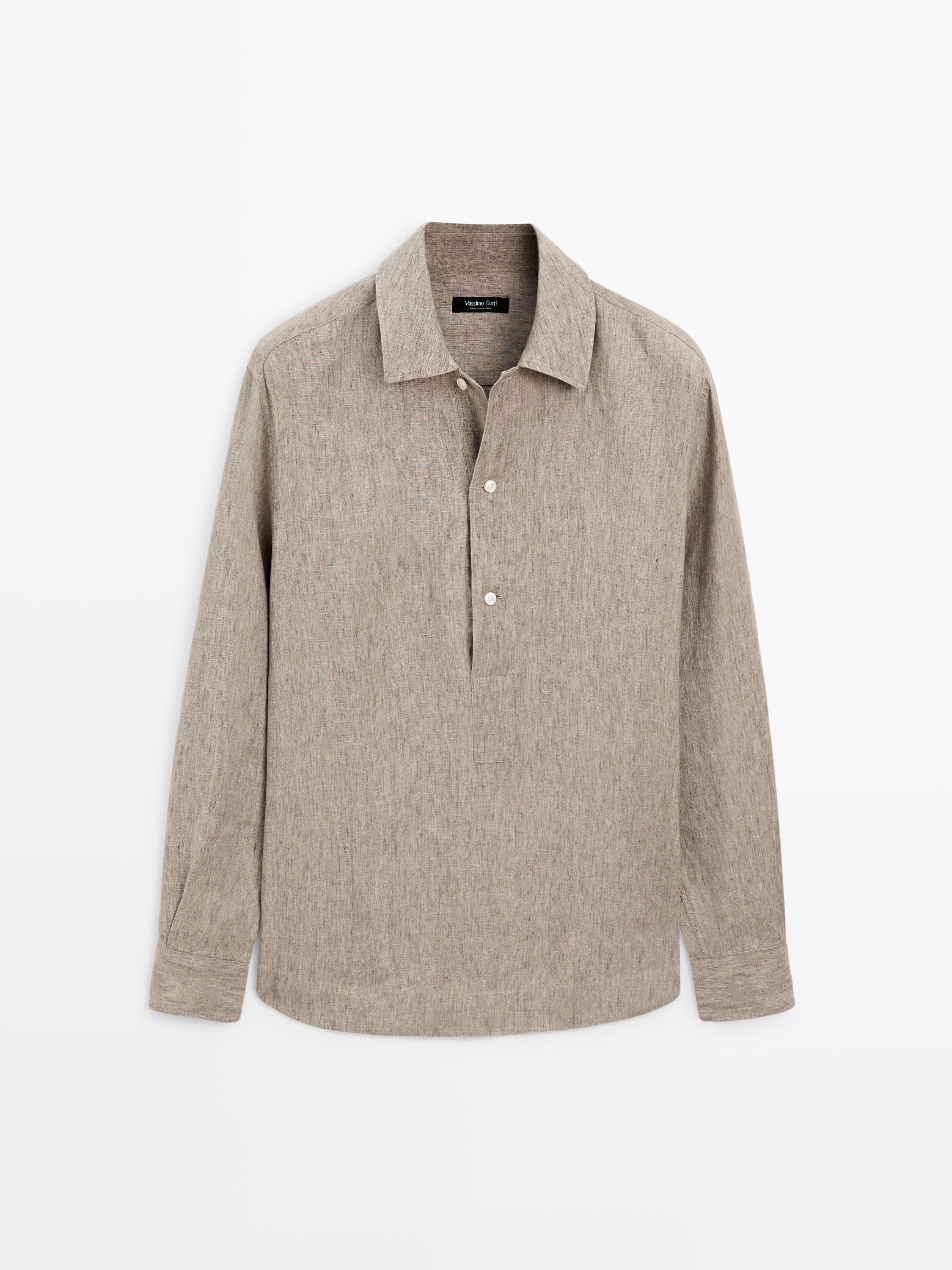 Vista frontal de camisa beige regular fit con cuello clásico, botonadura parcial y mangas largas.