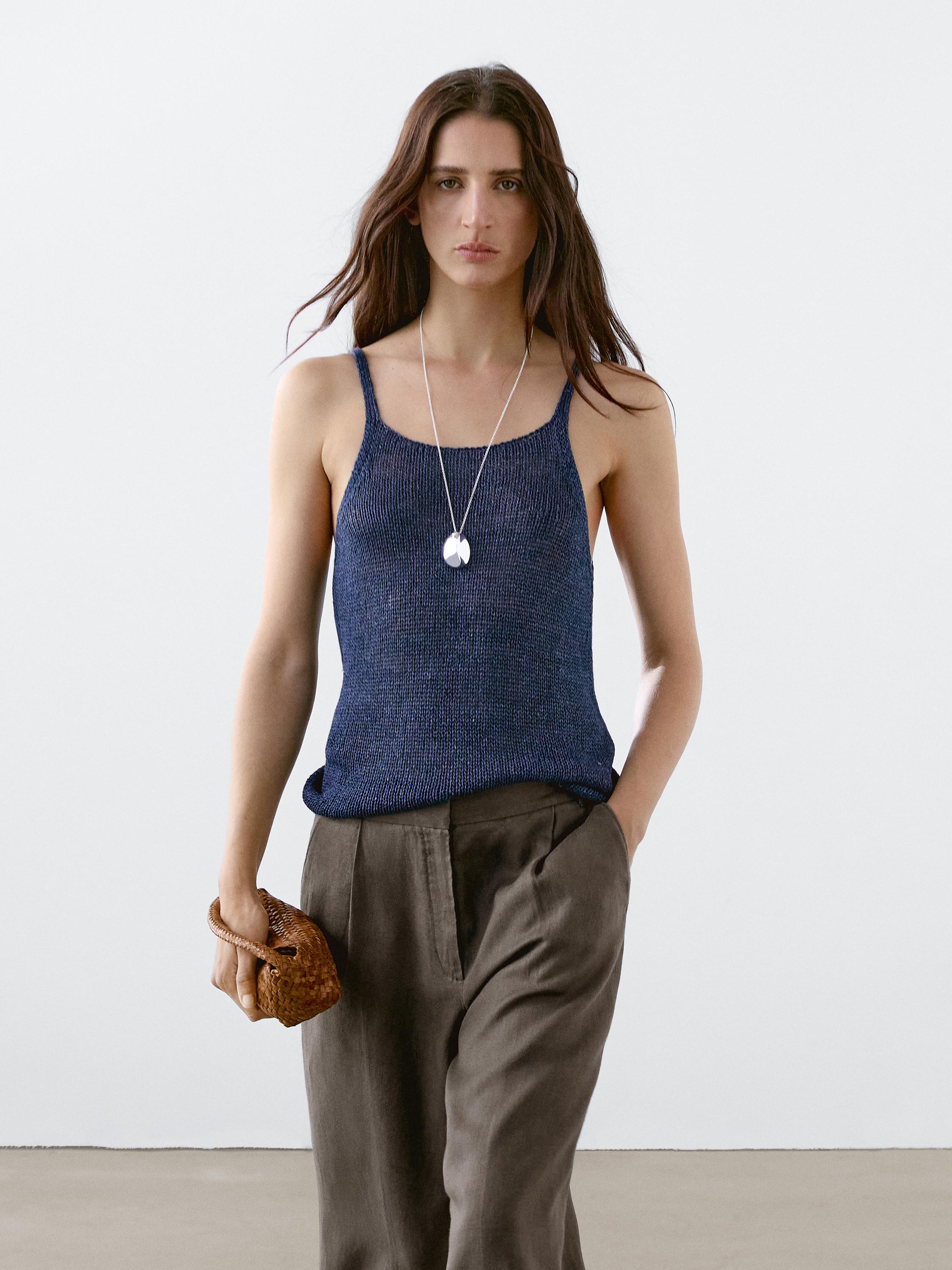 Conjunto de top azul oscuro de tirantes finos y pantalón marrón con bolsillos laterales